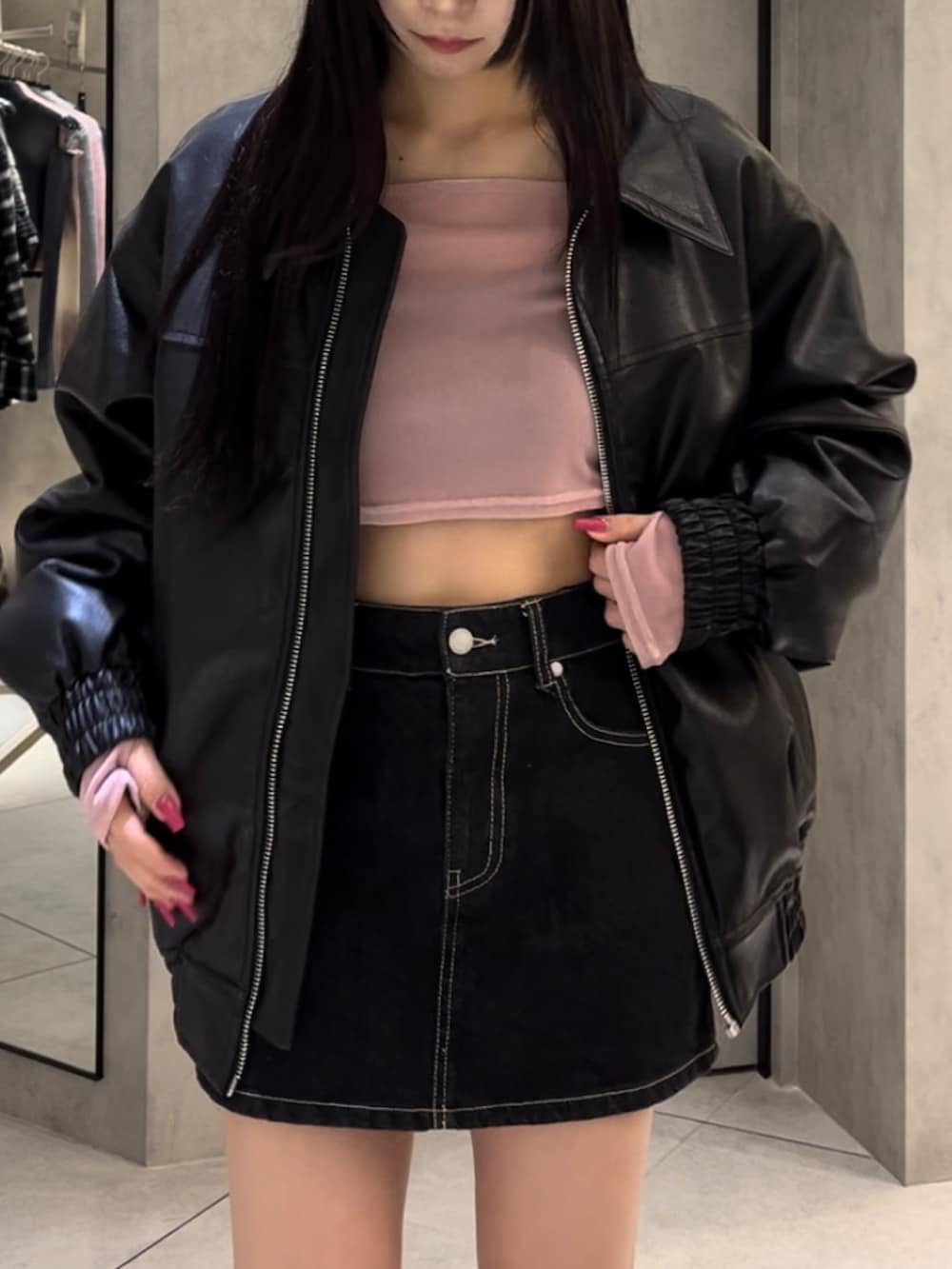 ブラック系のブルゾン、ピンク系のTシャツ/カットソー、ブルー系のスカートを着用したレディースの冬コーディネートの5枚目の写真