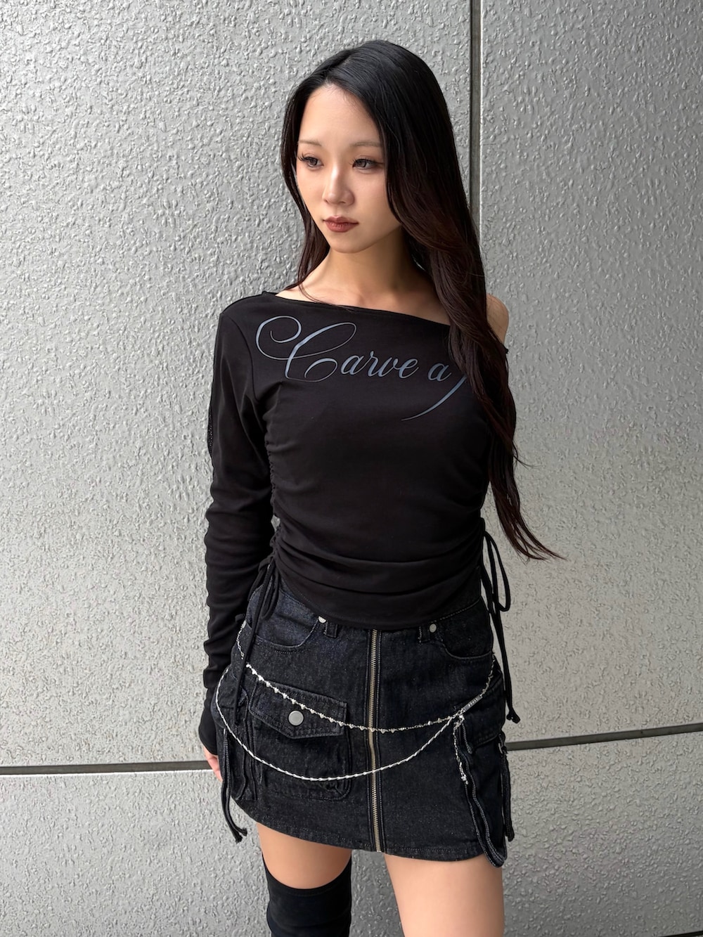 ブラック系のTシャツ/カットソー、ブラック系のスカート、ブラック系のブーツを着用したレディースの秋コーディネートの5枚目の写真