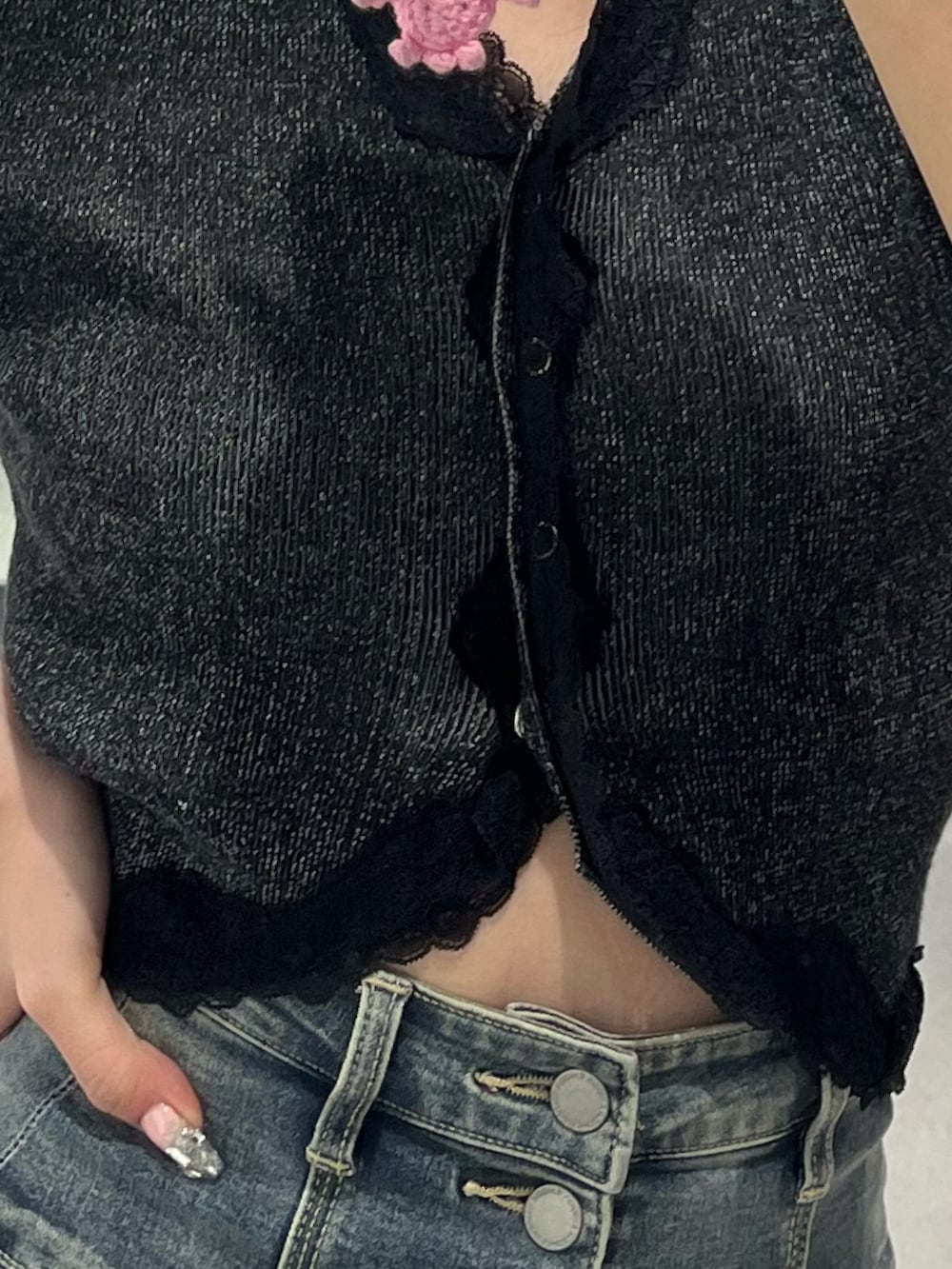 ブラック系のニット/セーター、ブルー系のデニムパンツ、ブラック系のサンダルを着用したレディースの春コーディネートの8枚目の写真