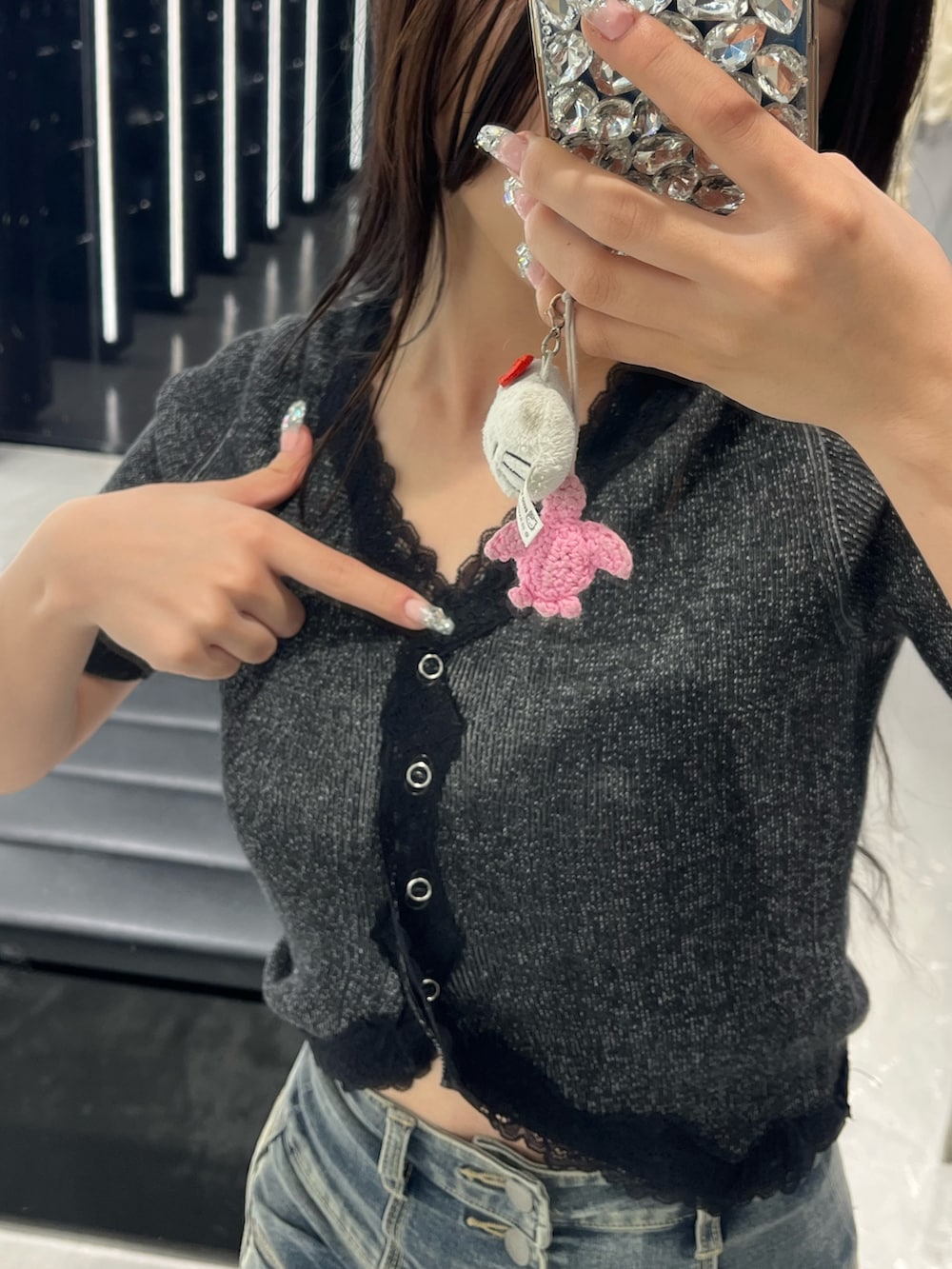 ブラック系のニット/セーター、ブルー系のデニムパンツ、ブラック系のサンダルを着用したレディースの春コーディネートの5枚目の写真