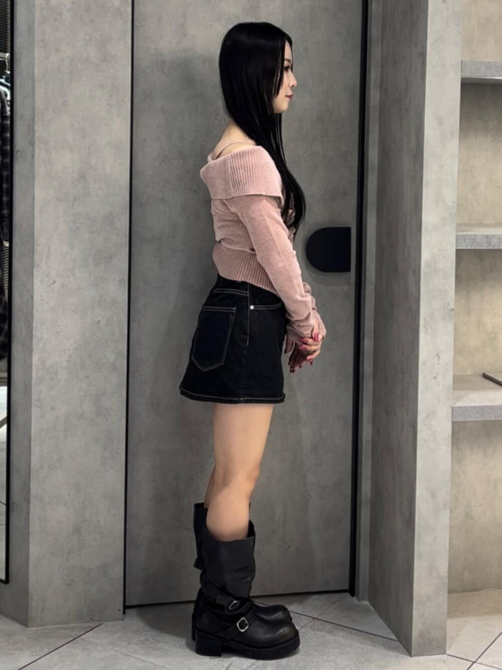 ブルー系のスカート、ブラック系のブーツ、ピンク系のニット/セーターを着用したレディースの冬コーディネートの2枚目の写真