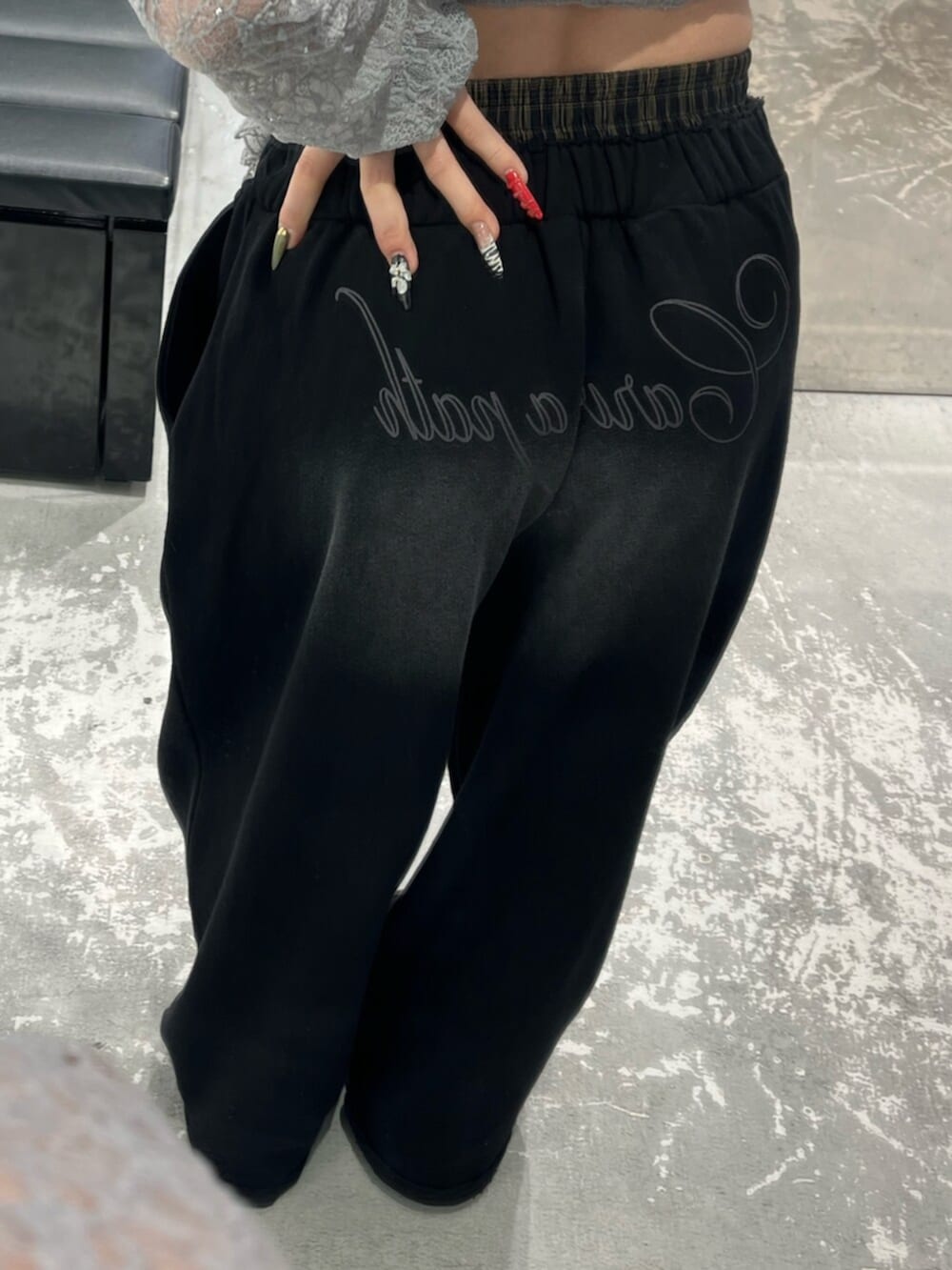 グレー系のTシャツ/カットソー、ブラック系のスウェットパンツ、ホワイト系のニット/セーターを着用したレディースの春コーディネートの9枚目の写真