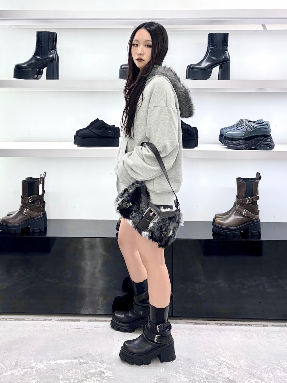 グレー系のパーカー、ブラック系のショルダーバッグ、ブラック系のその他パンツを着用したレディースの秋コーディネートの2枚目の写真