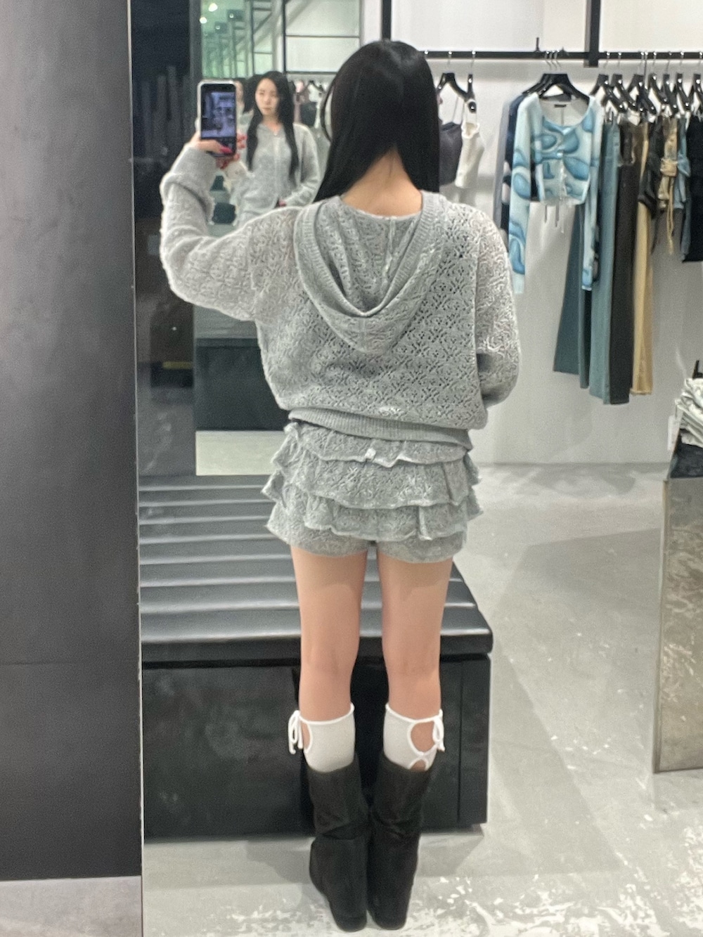 グレー系のパーカー、グレー系のスカート、ブラック系のサンダルを着用したレディースの春コーディネートの3枚目の写真