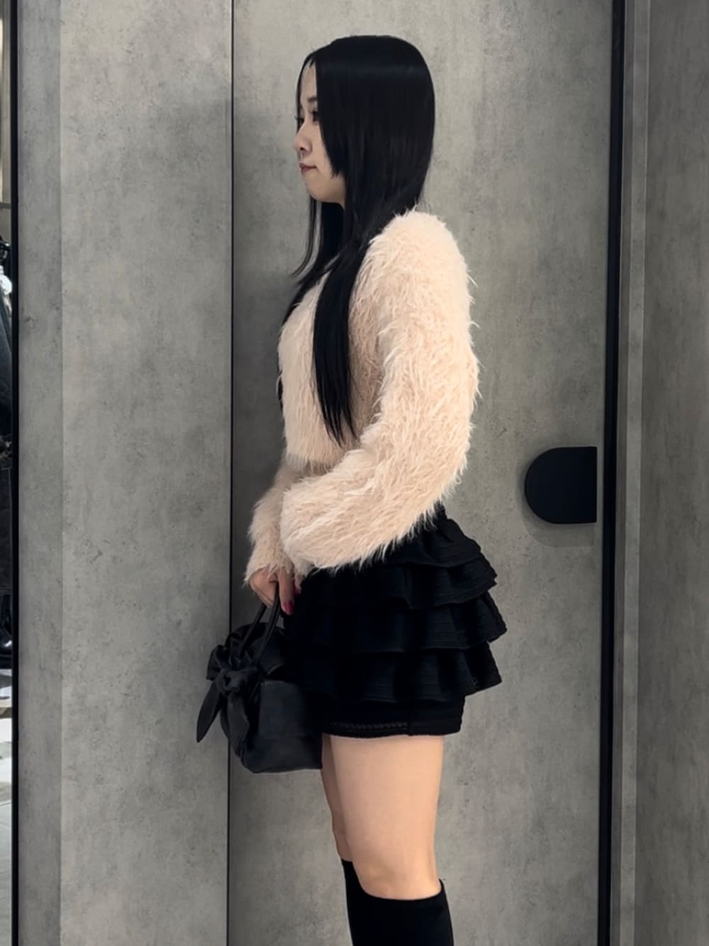 ピンク系のニット/セーター、ブラック系のハンドバッグ、ブラック系のその他パンツを着用したレディースの冬コーディネートの9枚目の写真