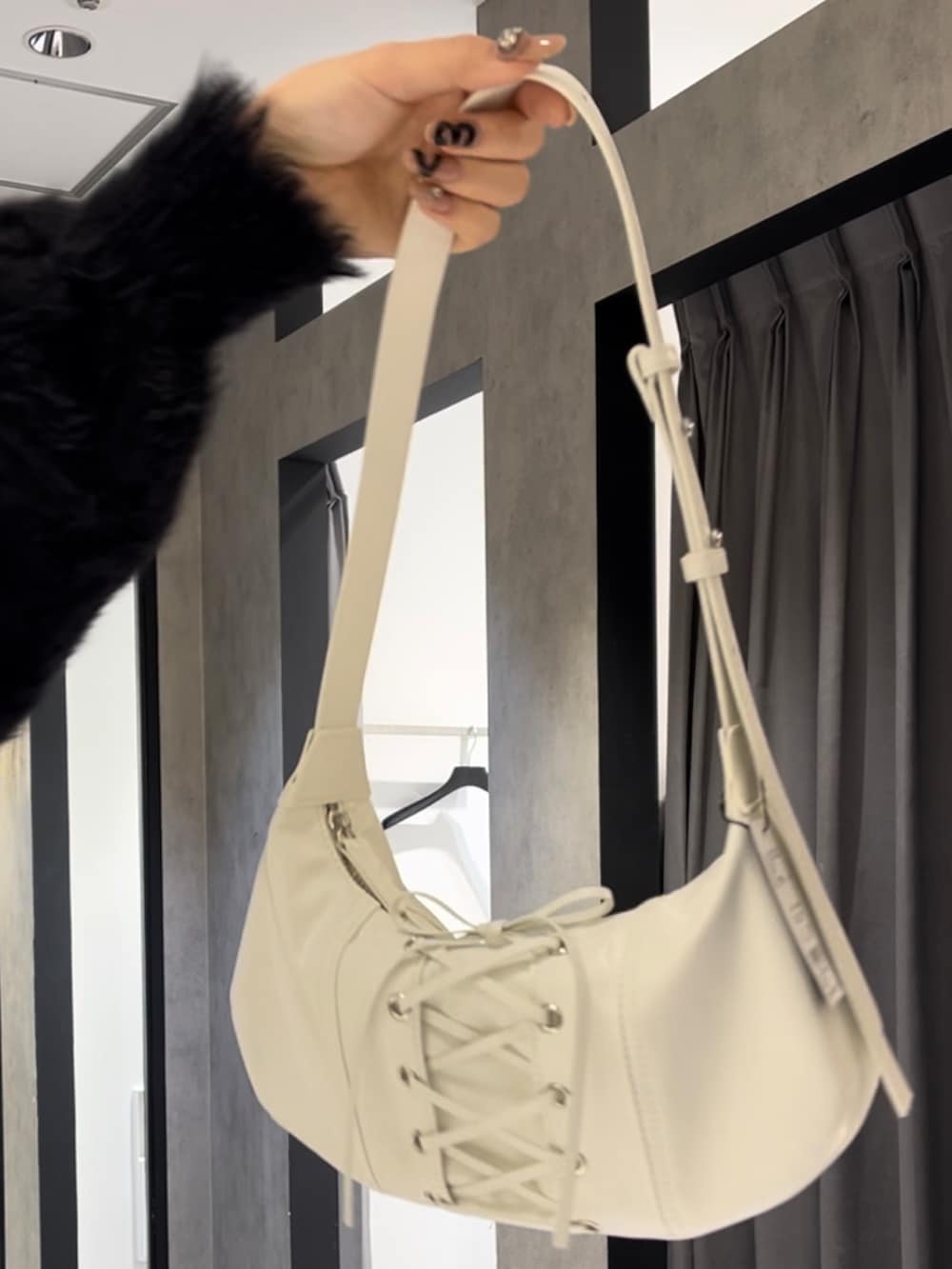 ブラック系のニット/セーター、グレー系のスウェットパンツ、ホワイト系のショルダーバッグを着用したレディースの冬コーディネートの10枚目の写真