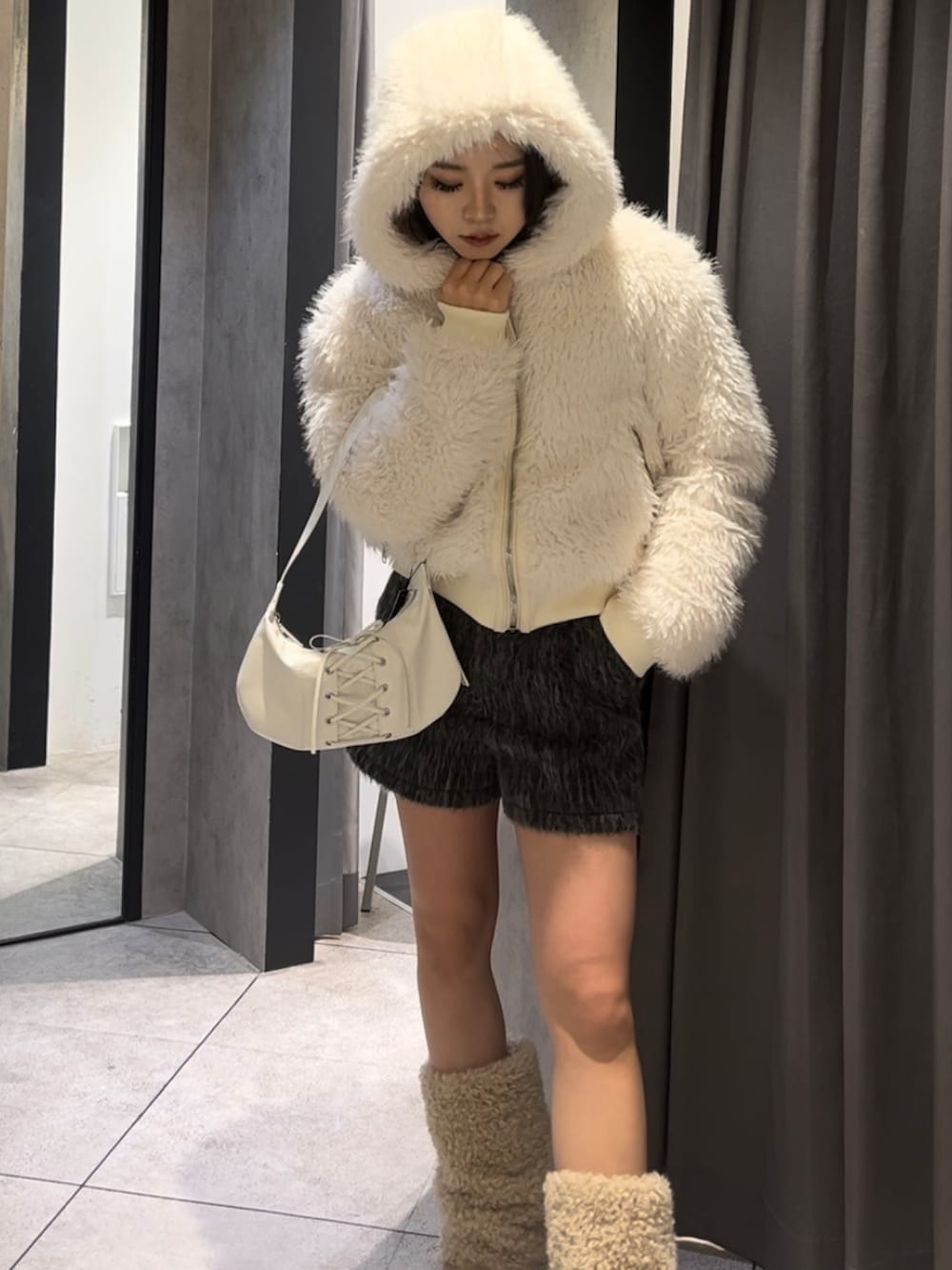 ホワイト系のブルゾン、ブラック系のニット/セーター、グレー系のその他パンツを着用したレディースの冬コーディネートの9枚目の写真