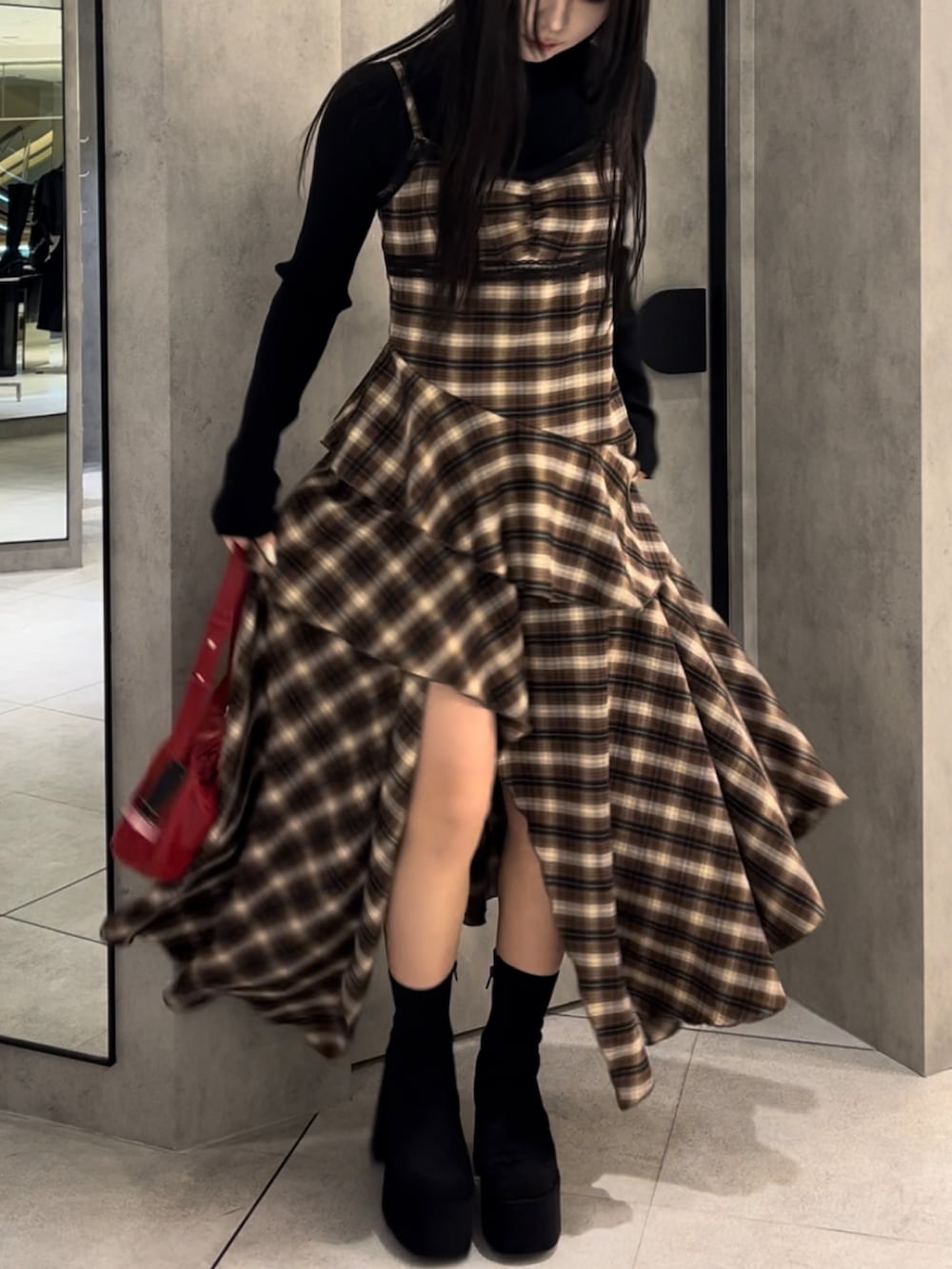 ブラック系のニット/セーター、ベージュ系のワンピース、レッド系のショルダーバッグを着用したレディースの冬コーディネートの8枚目の写真