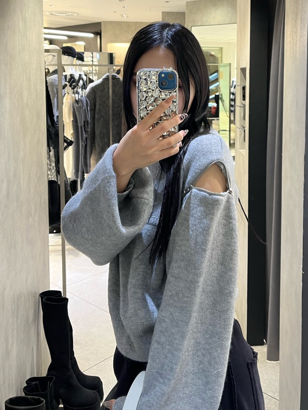 グレー系のパーカー、ブラック系のローファー、ホワイト系のショルダーバッグを着用したレディースの冬コーディネートの6枚目の写真