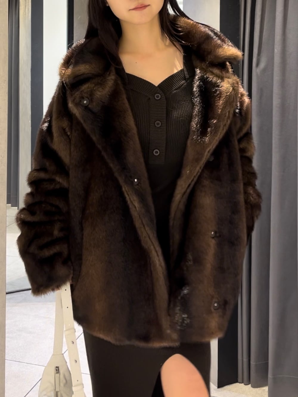 ブラウン系のその他アウター、ホワイト系のショルダーバッグ、ブラック系のブーツを着用したレディースの冬コーディネートの4枚目の写真