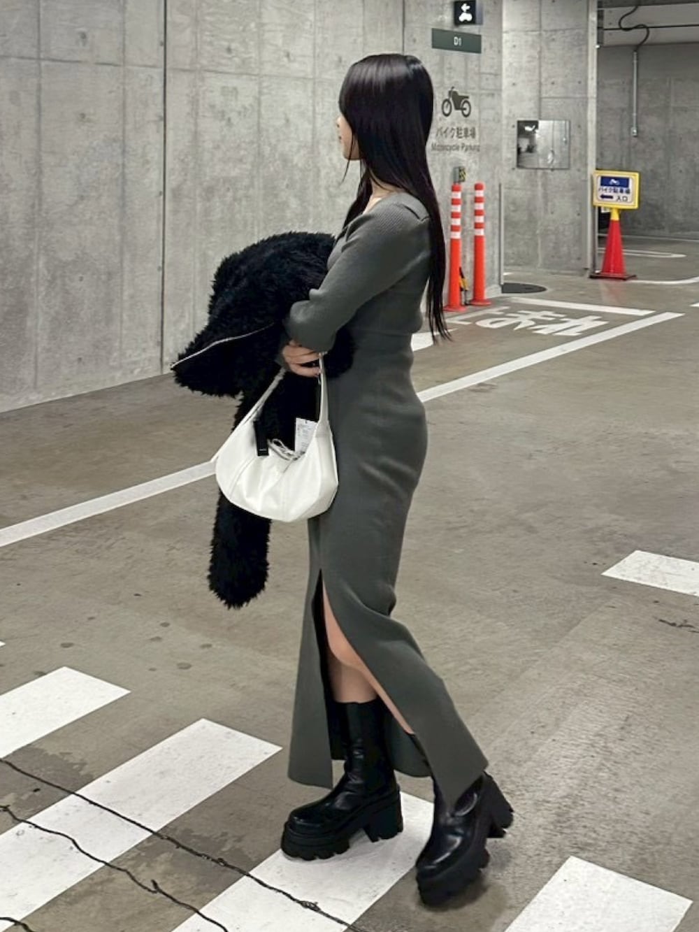 ブラック系のブルゾン、グレー系のワンピース、ホワイト系のショルダーバッグを着用したレディースの冬コーディネートの10枚目の写真