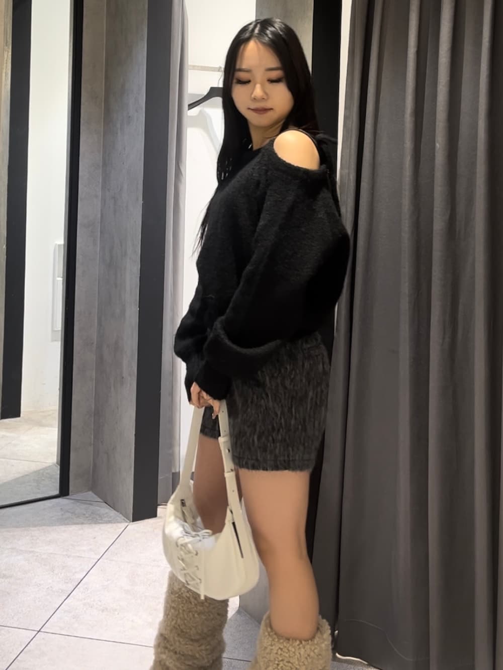 ホワイト系のブルゾン、ブラック系のニット/セーター、グレー系のその他パンツを着用したレディースの冬コーディネートの7枚目の写真