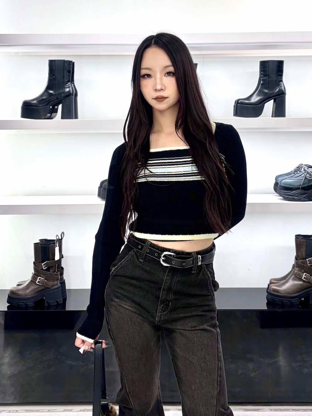 ブラック系のニット/セーター、その他のショルダーバッグ、ブラック系のデニムパンツを着用したレディースの秋コーディネートの5枚目の写真