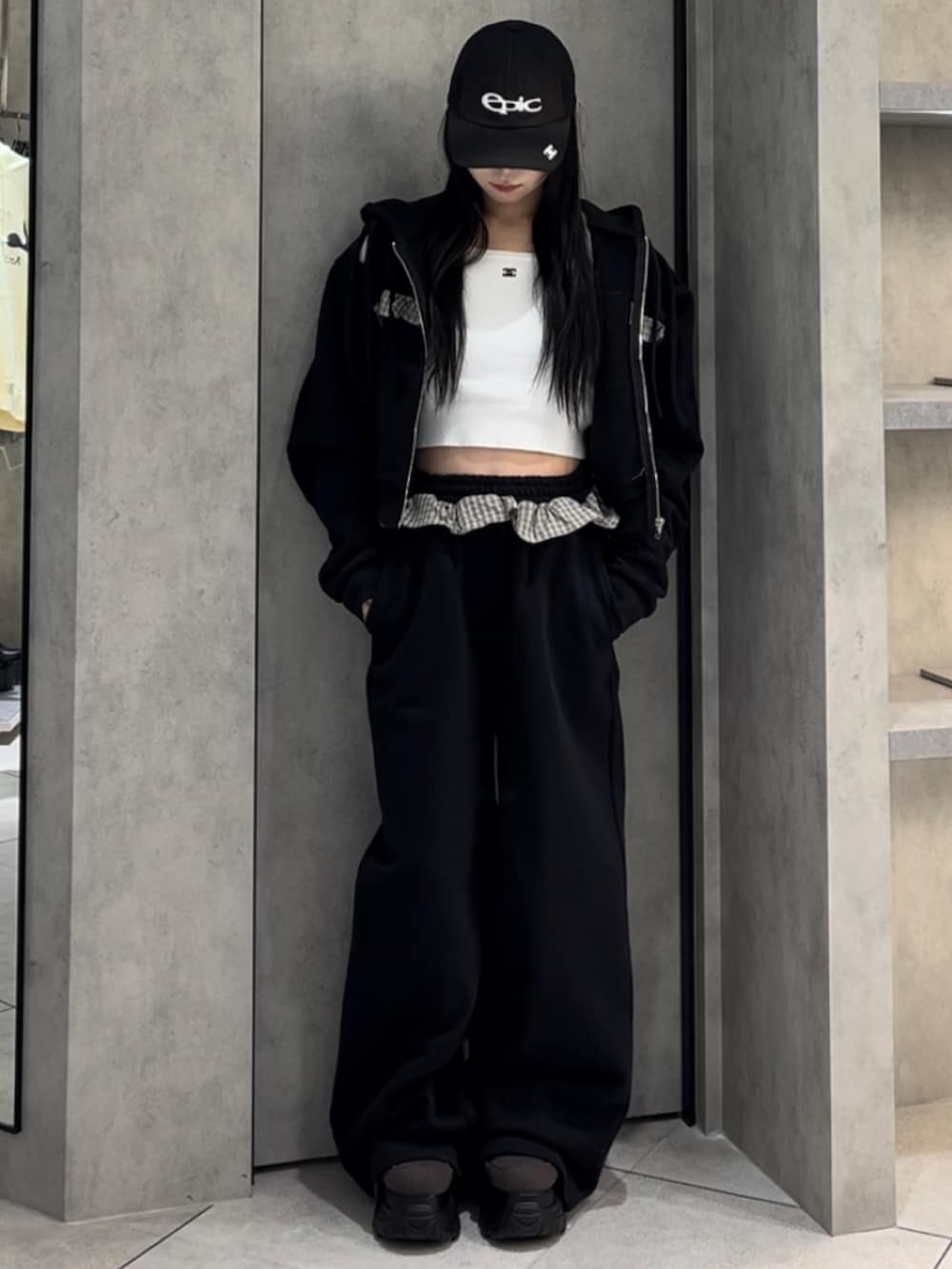 ホワイト系のニット/セーター、ブラック系のパーカー、ブラック系のスウェットパンツを着用したレディースの冬コーディネートの10枚目の写真