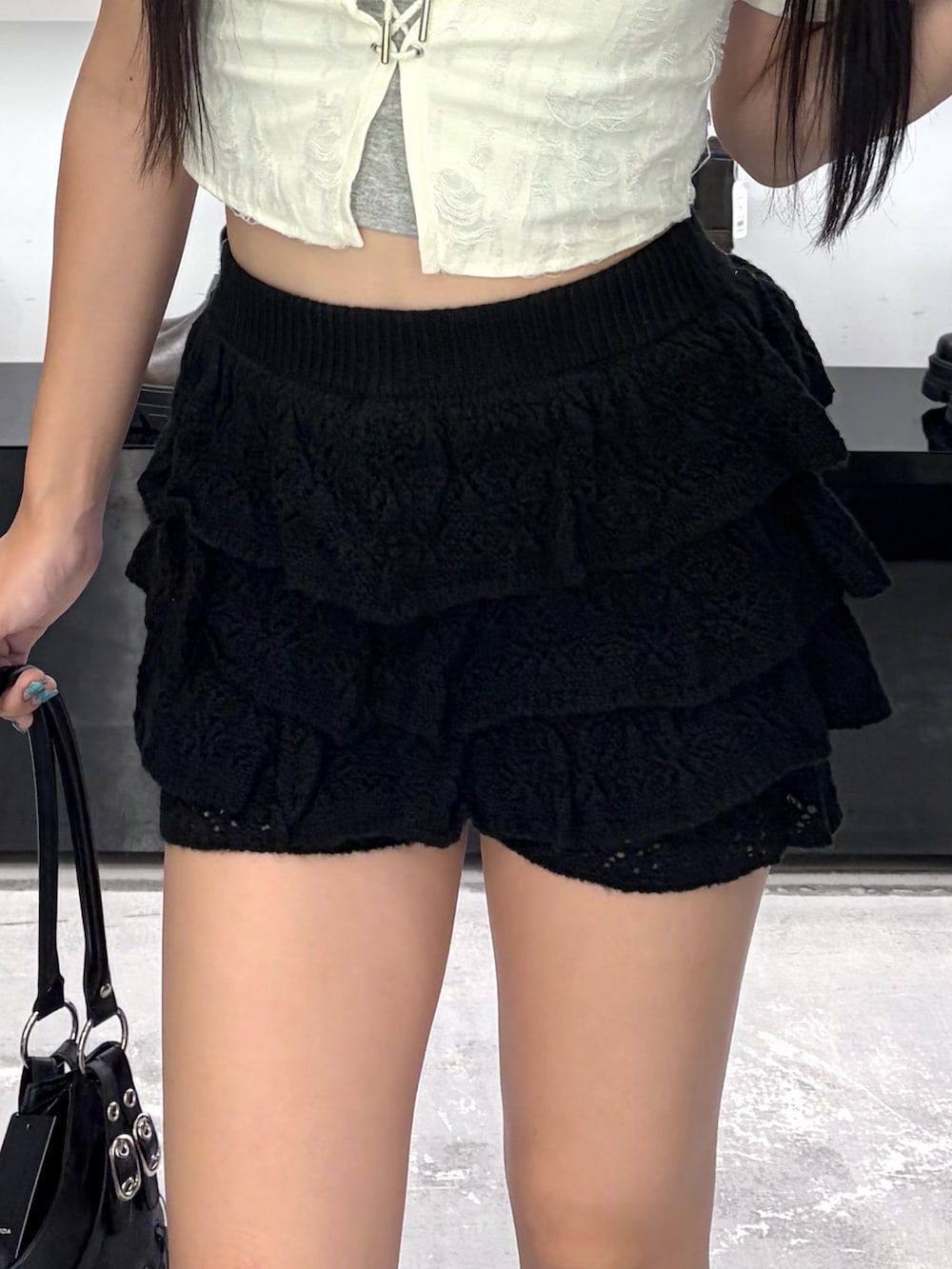 ホワイト系のTシャツ/カットソー、ブラック系のスカート、ブラック系のブーツを着用したレディースの夏コーディネートの8枚目の写真