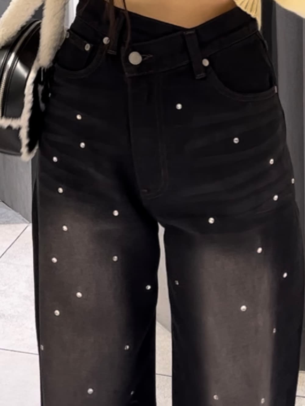 イエロー系のニット/セーター、ブラック系のデニムパンツ、ブラック系のハンドバッグを着用したレディースの冬コーディネートの10枚目の写真