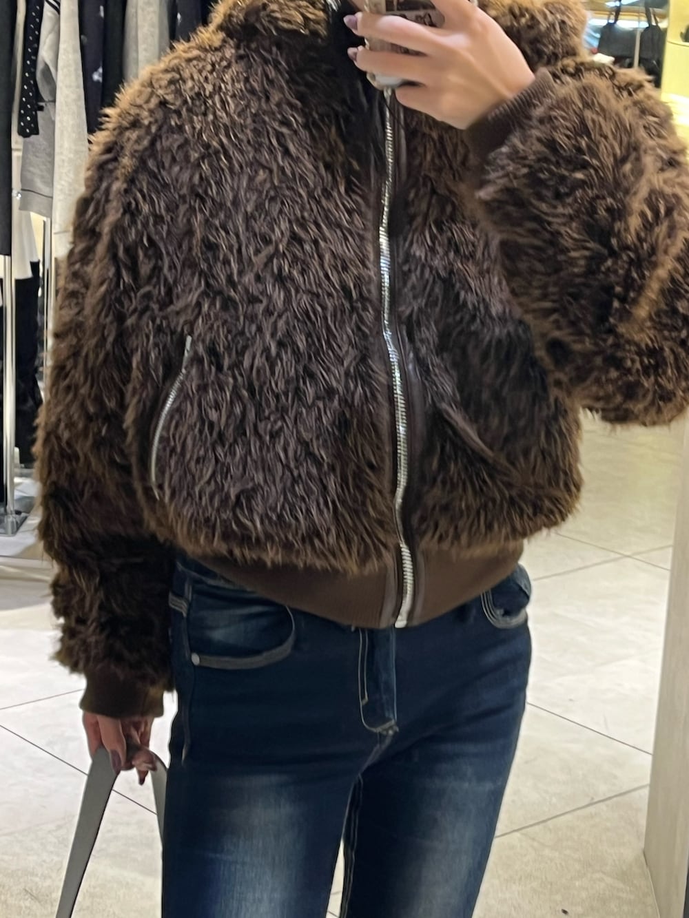 ブラウン系のブルゾン、ブルー系のデニムパンツ、ブラック系のブーツを着用したレディースの秋コーディネートの7枚目の写真