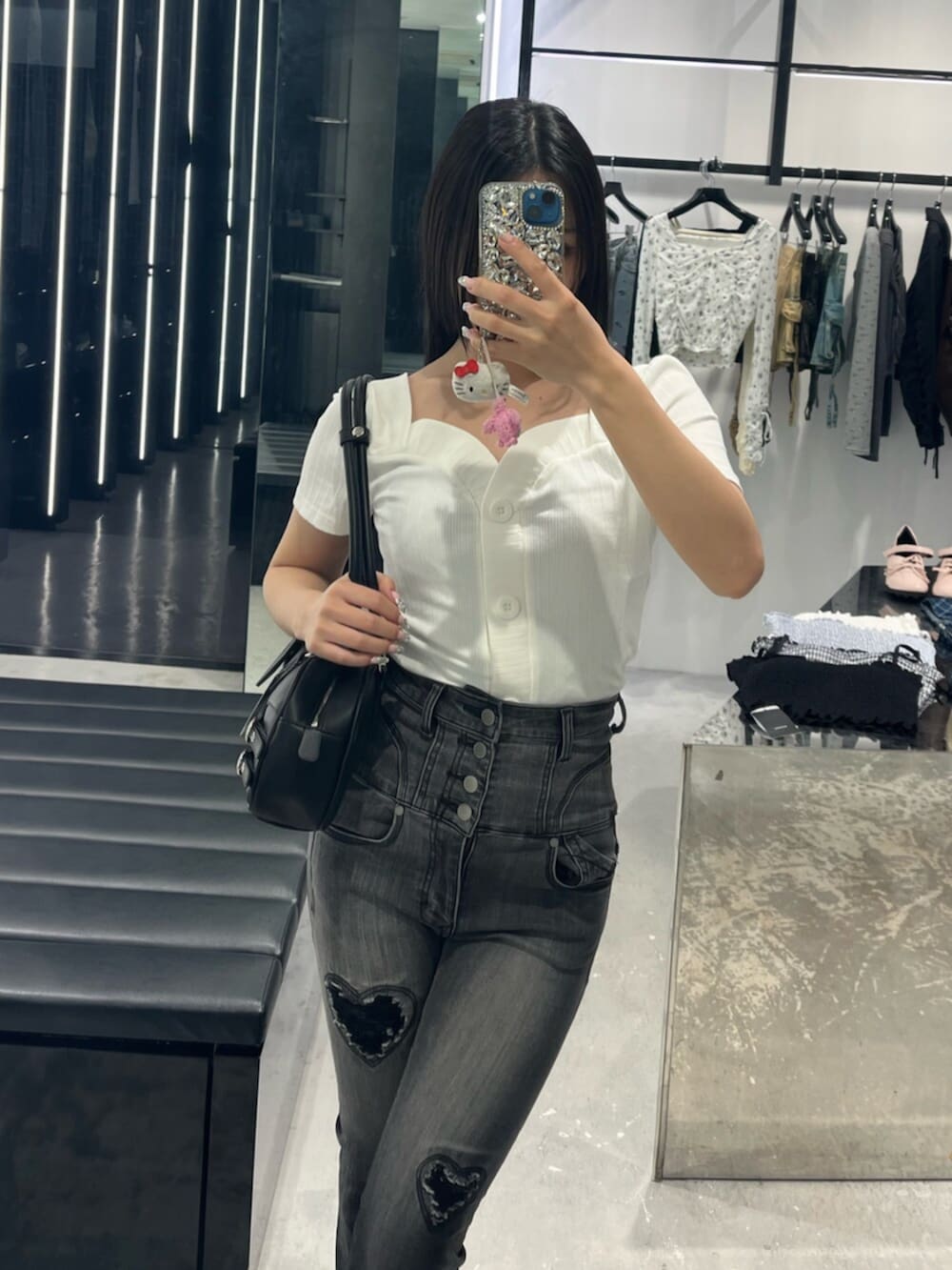 ブラック系のデニムパンツ、ブラック系のサンダル、ホワイト系のTシャツ/カットソーを着用したレディースの春コーディネートの4枚目の写真