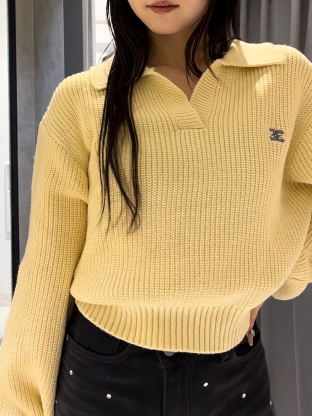 イエロー系のニット/セーター、ブラック系のデニムパンツ、ブラック系のハンドバッグを着用したレディースの冬コーディネートの9枚目の写真