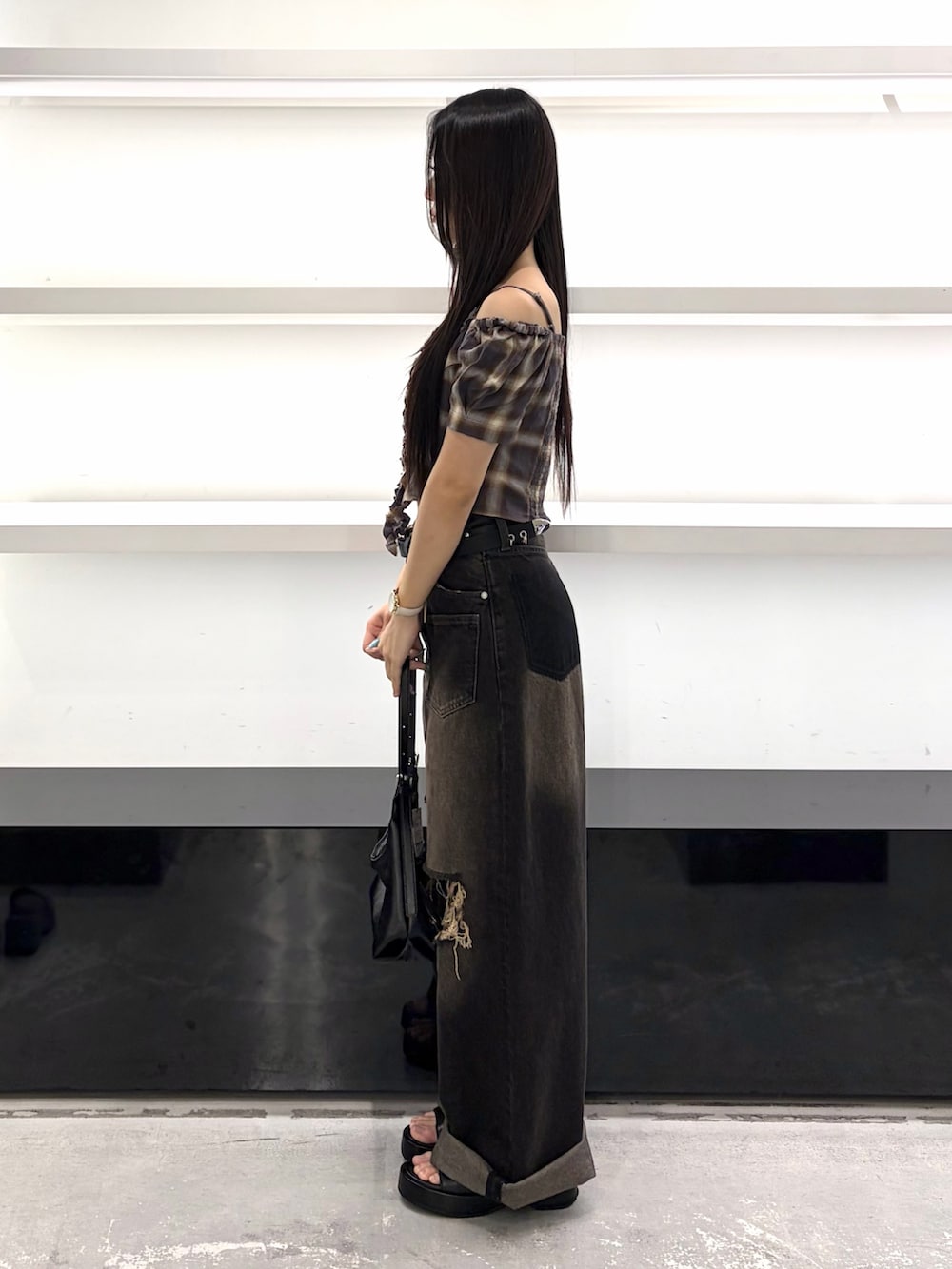 ブラウン系のTシャツ/カットソー、ブラック系のハンドバッグ、ブラック系のデニムパンツを着用したレディースの夏コーディネートの2枚目の写真
