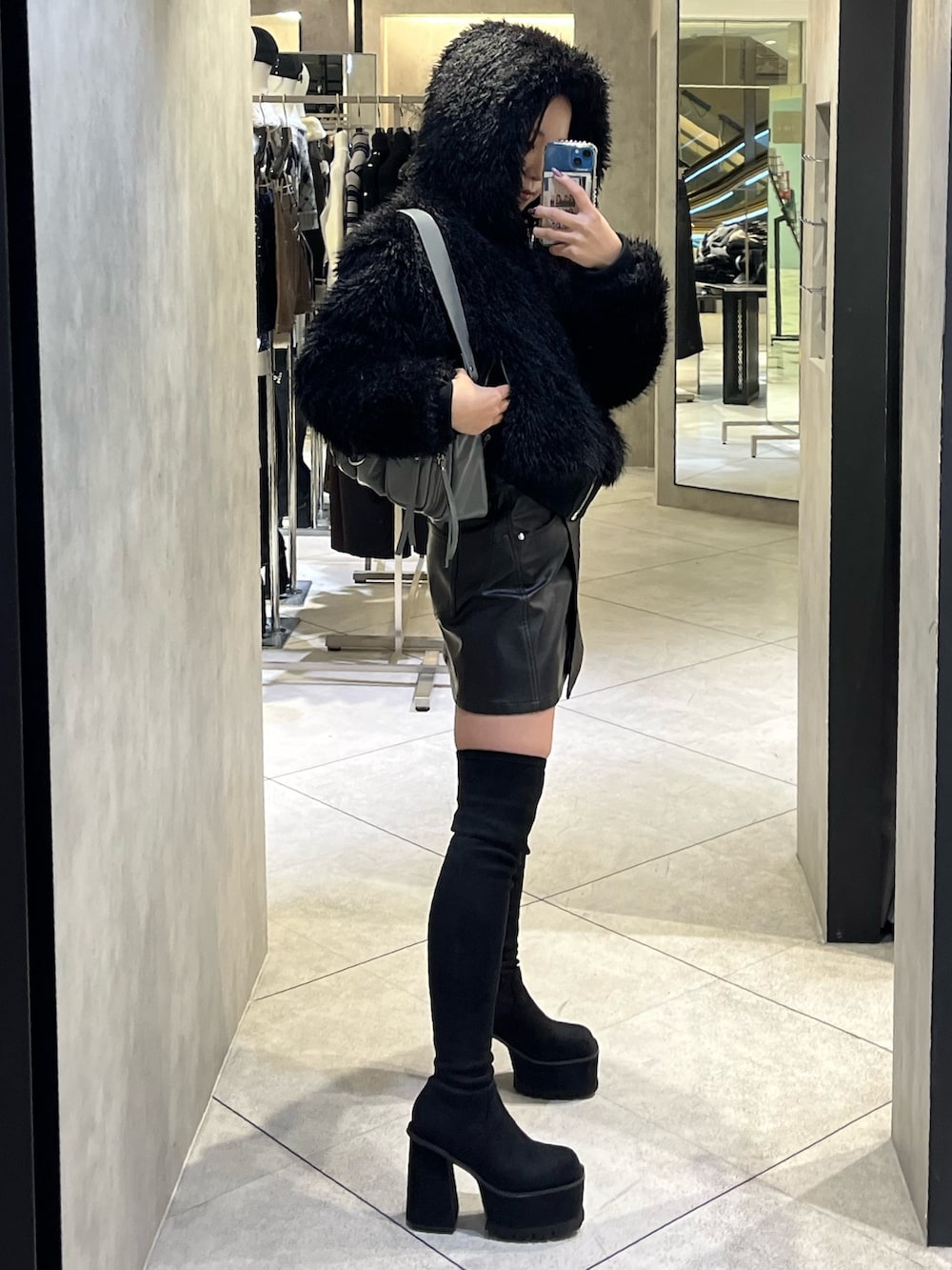 ブラック系のブーツ、グレー系のハンドバッグ、ブラック系のスカートを着用したレディースの秋コーディネートの3枚目の写真