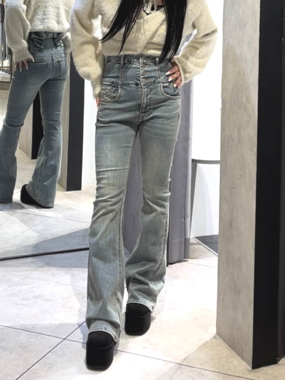 ブルー系のデニムパンツ、ホワイト系のニット/セーター、ブラック系のブーツを着用したレディースの冬コーディネートの8枚目の写真