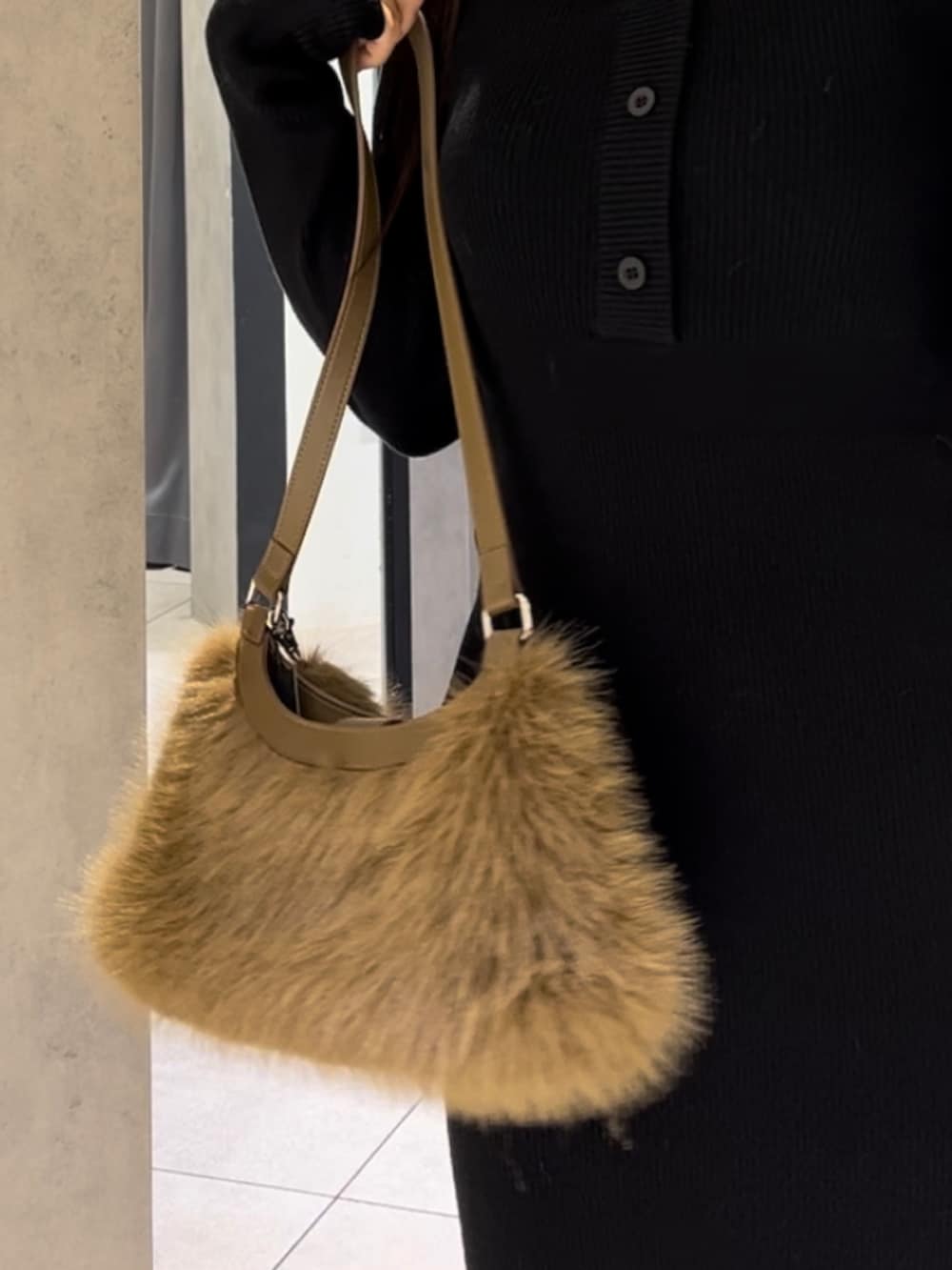 ブラック系のワンピース、ベージュ系のショルダーバッグ、ブラック系のブーツを着用したレディースの冬コーディネートの8枚目の写真