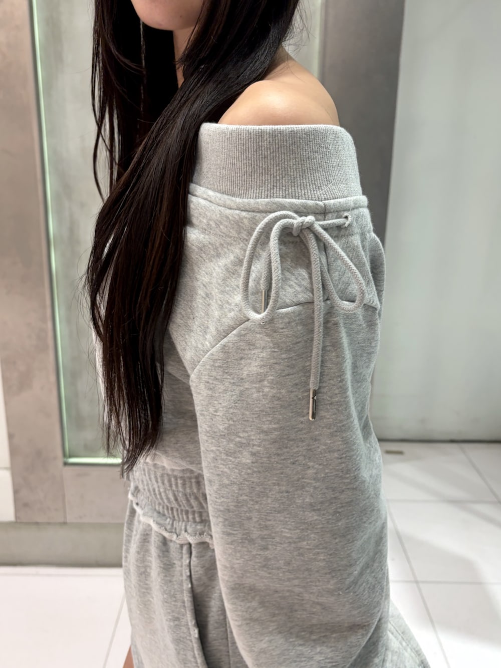 グレー系のTシャツ/カットソー、グレー系のスカート、ブラック系のブーツを着用したレディースの秋コーディネートの6枚目の写真
