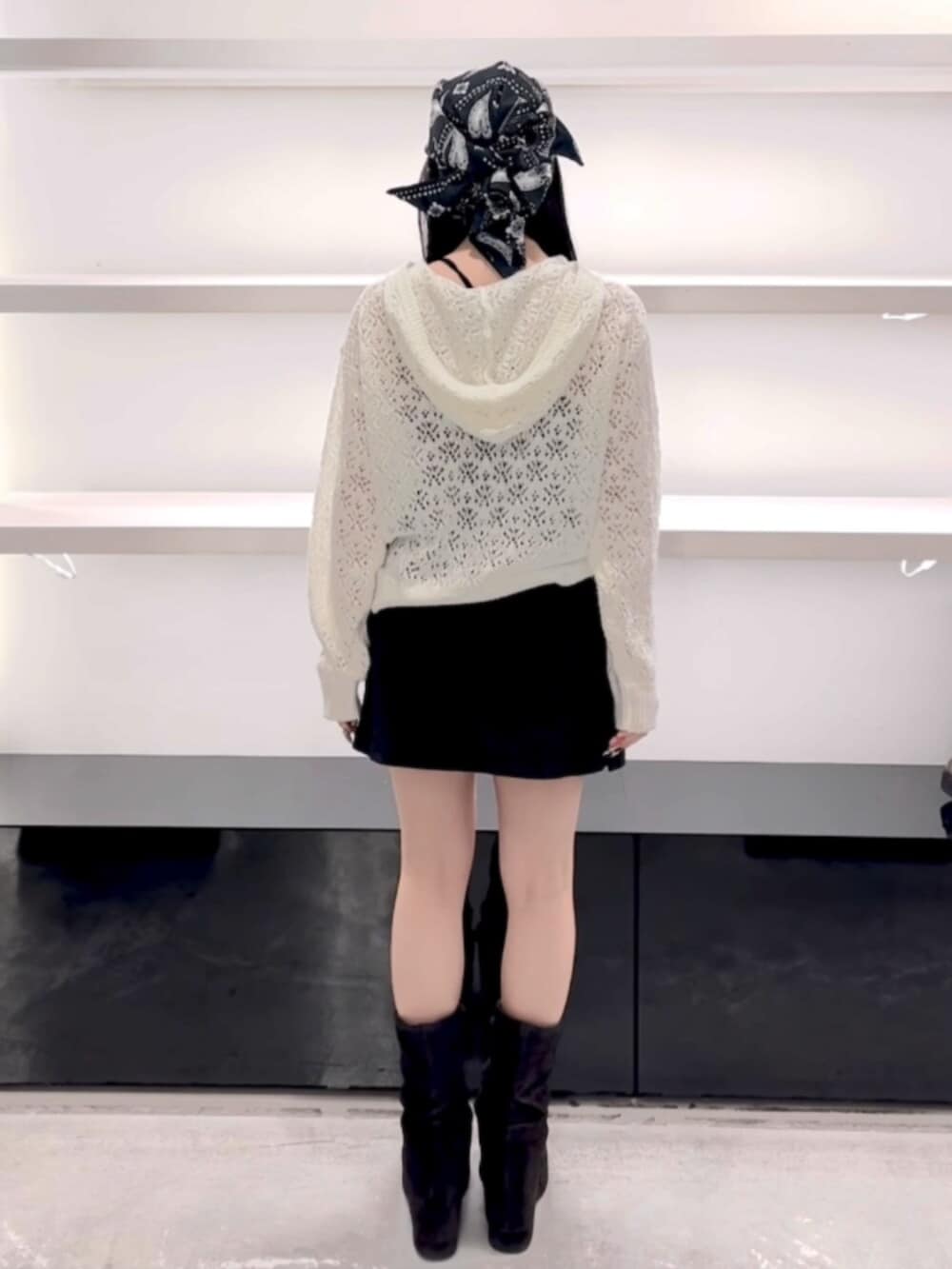 ブラック系のサンダル、ホワイト系のパーカー、ブラック系のスカートを着用したレディースの春コーディネートの4枚目の写真