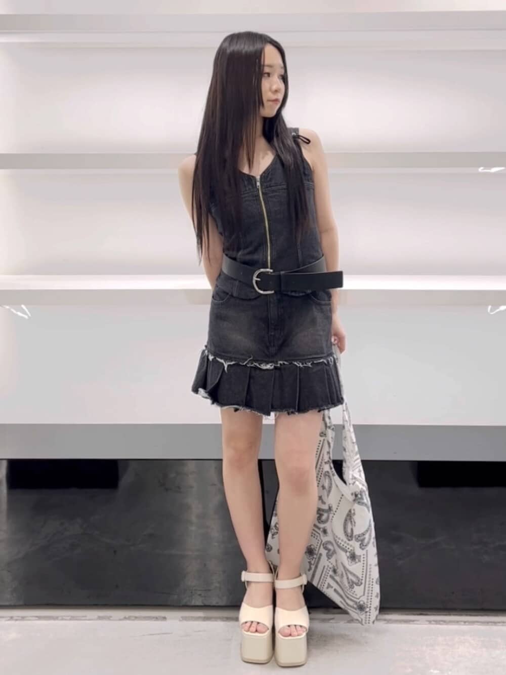 ホワイト系のサンダル、ホワイト系のトートバッグ、ブラック系のワンピースを着用したレディースの春コーディネートの2枚目の写真