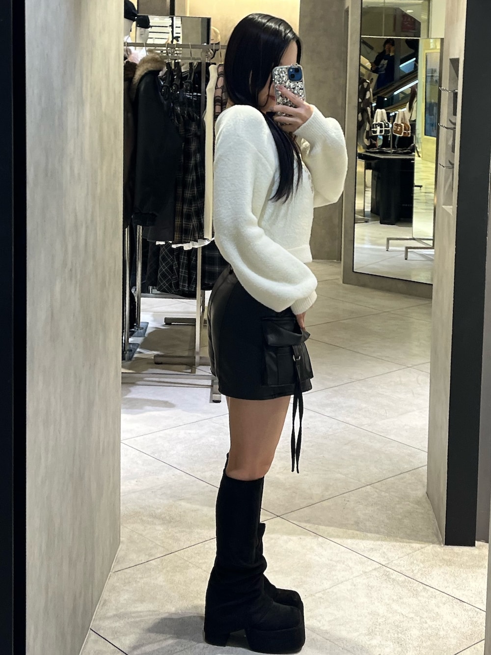 ホワイト系のニット/セーター、ブラック系のその他パンツ、ブラック系のブーツを着用したレディースの冬コーディネートの2枚目の写真