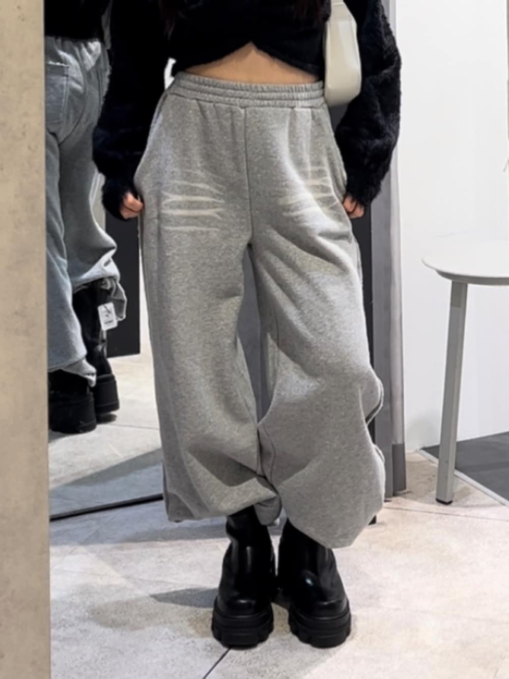 ブラック系のニット/セーター、グレー系のスウェットパンツ、ホワイト系のショルダーバッグを着用したレディースの冬コーディネートの8枚目の写真