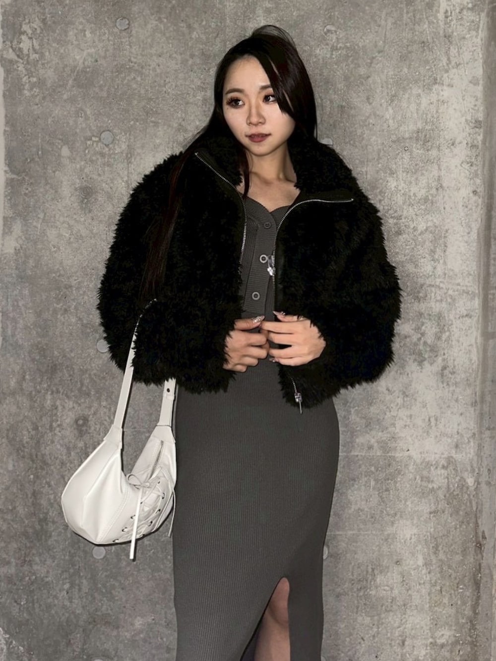 ブラック系のブルゾン、グレー系のワンピース、ホワイト系のショルダーバッグを着用したレディースの冬コーディネートの5枚目の写真