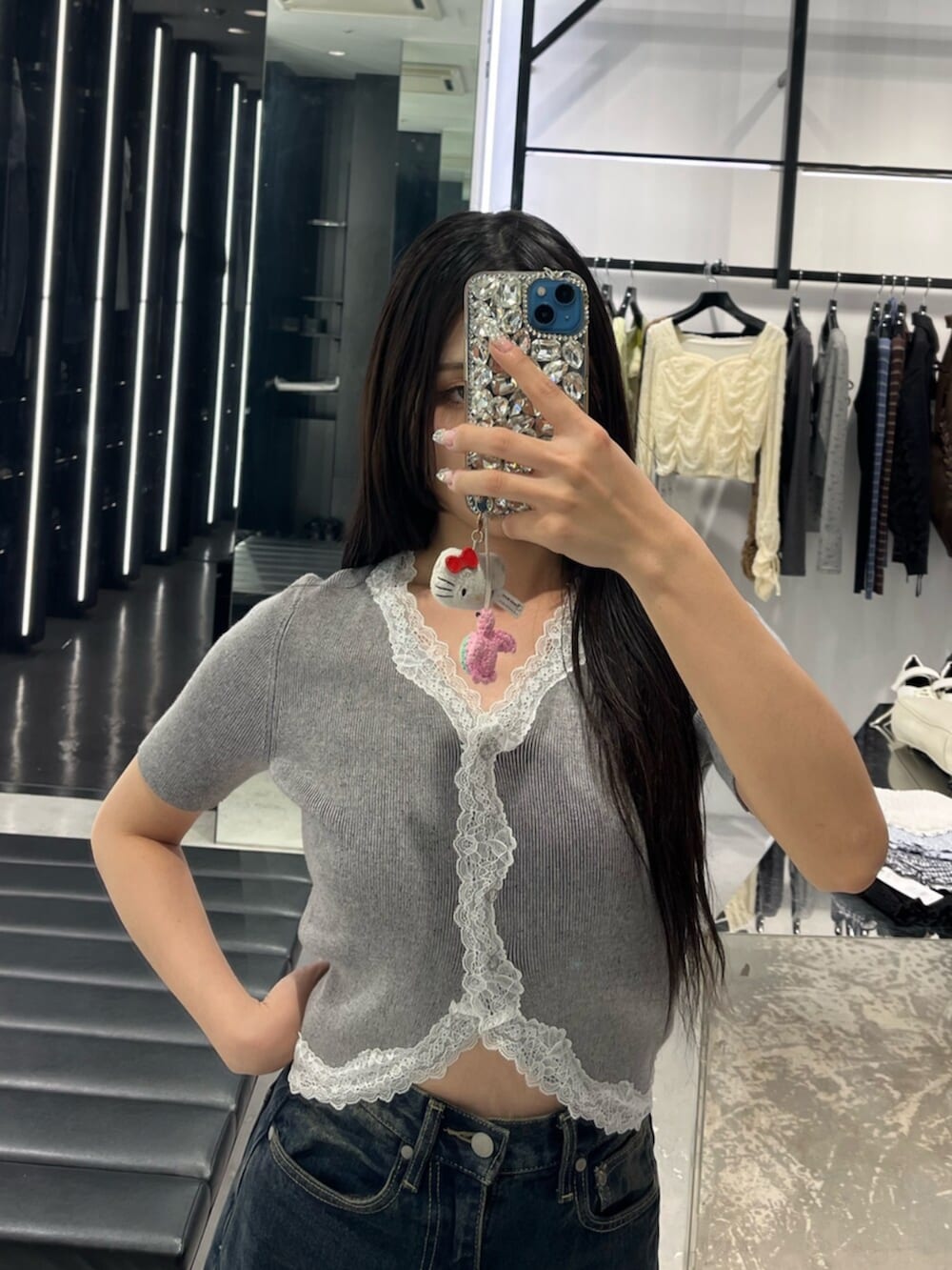 ブルー系のデニムパンツ、グレー系のニット/セーター、ブラック系のサンダルを着用したレディースの春コーディネートの4枚目の写真