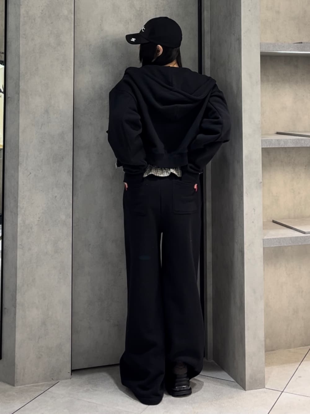 ホワイト系のニット/セーター、ブラック系のパーカー、ブラック系のスウェットパンツを着用したレディースの冬コーディネートの3枚目の写真