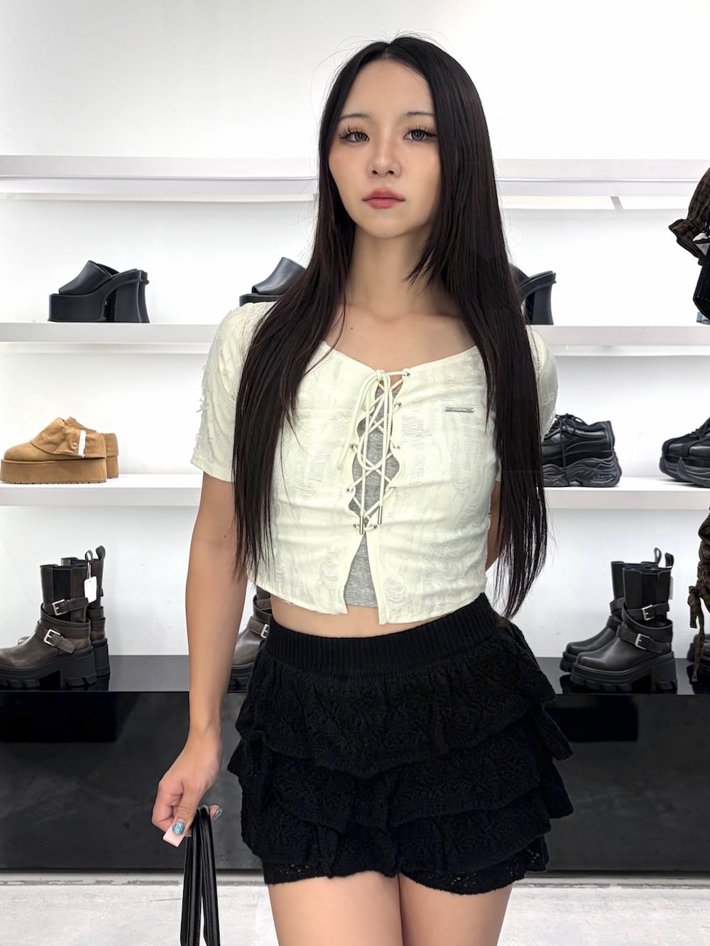 ホワイト系のTシャツ/カットソー、ブラック系のスカート、ブラック系のブーツを着用したレディースの夏コーディネートの6枚目の写真