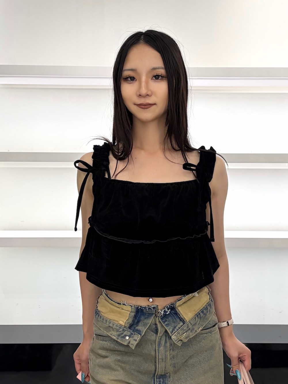 ブラック系のタンクトップ、ブラウン系のデニムパンツ、ブラウン系のブーツを着用したレディースの夏コーディネートの6枚目の写真