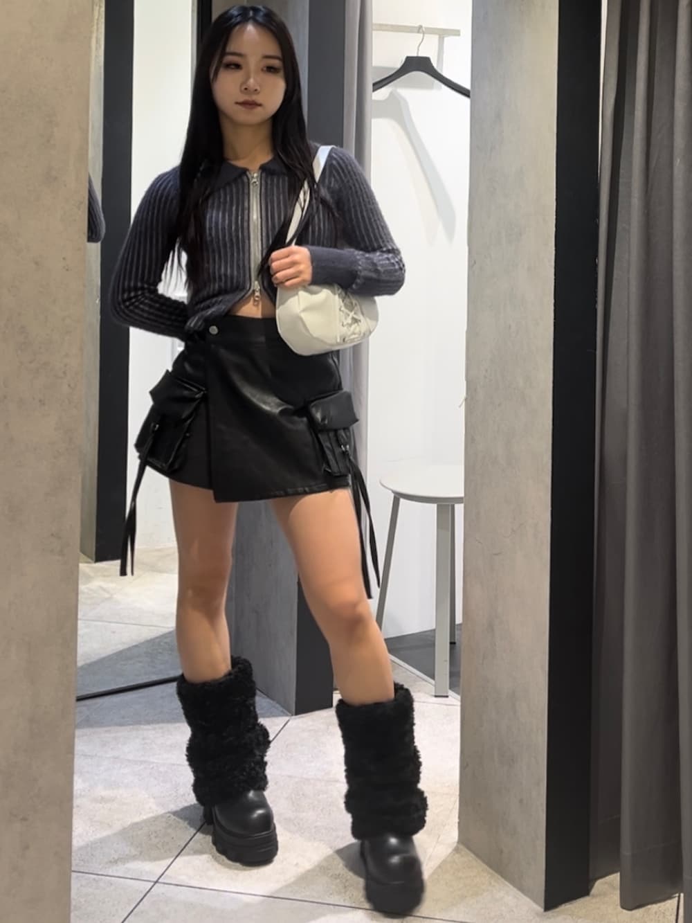 ホワイト系のブルゾン、ブルー系のニット/セーター、ブラック系のその他パンツを着用したレディースの冬コーディネートの8枚目の写真