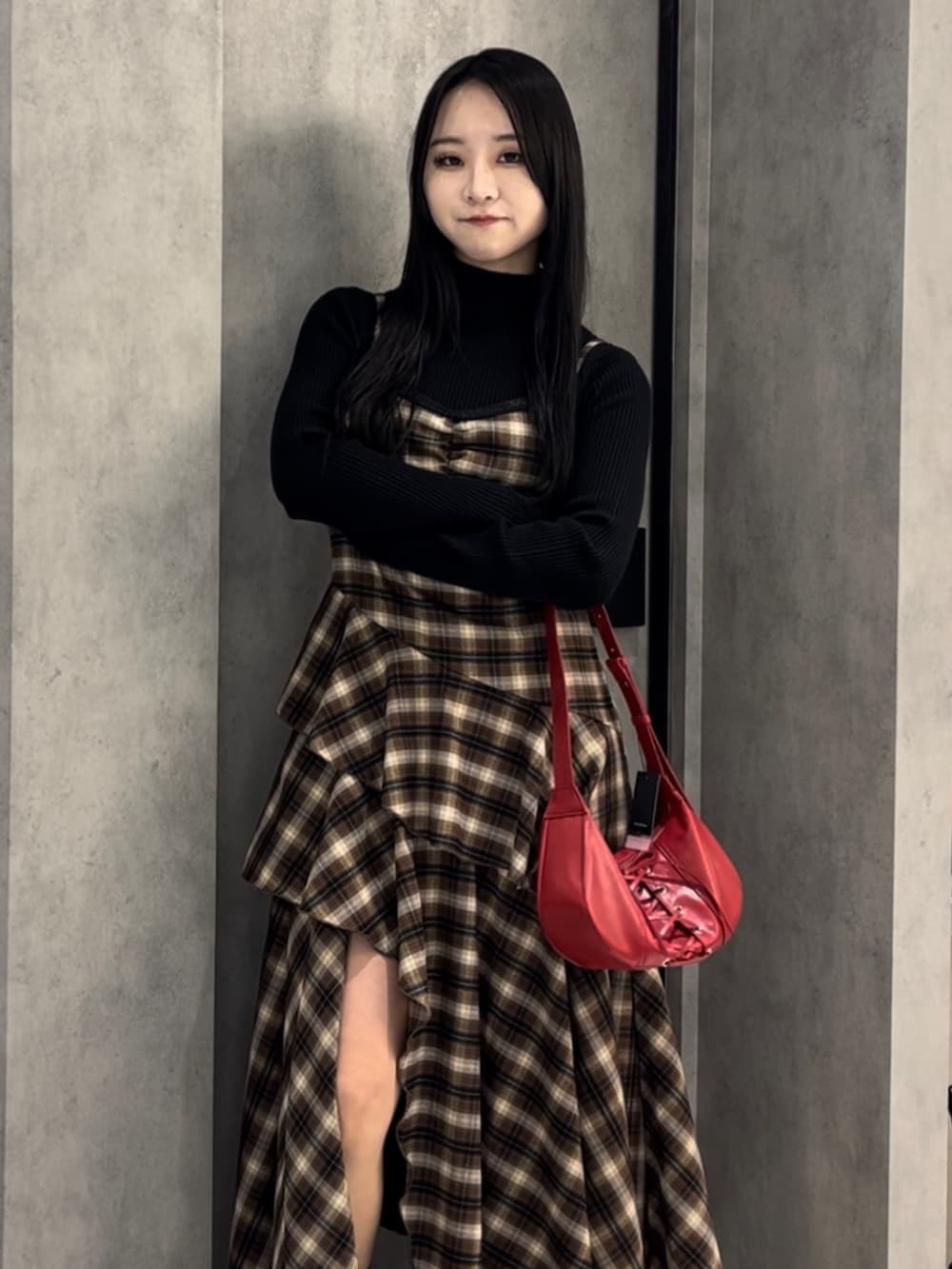 ブラック系のニット/セーター、ベージュ系のワンピース、レッド系のショルダーバッグを着用したレディースの冬コーディネートの4枚目の写真