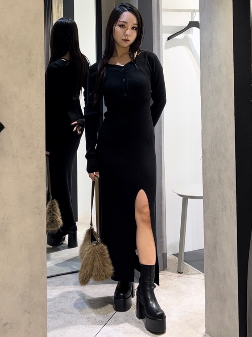 ブラック系のワンピース、ベージュ系のショルダーバッグ、ブラック系のブーツを着用したレディースの冬コーディネートの9枚目の写真