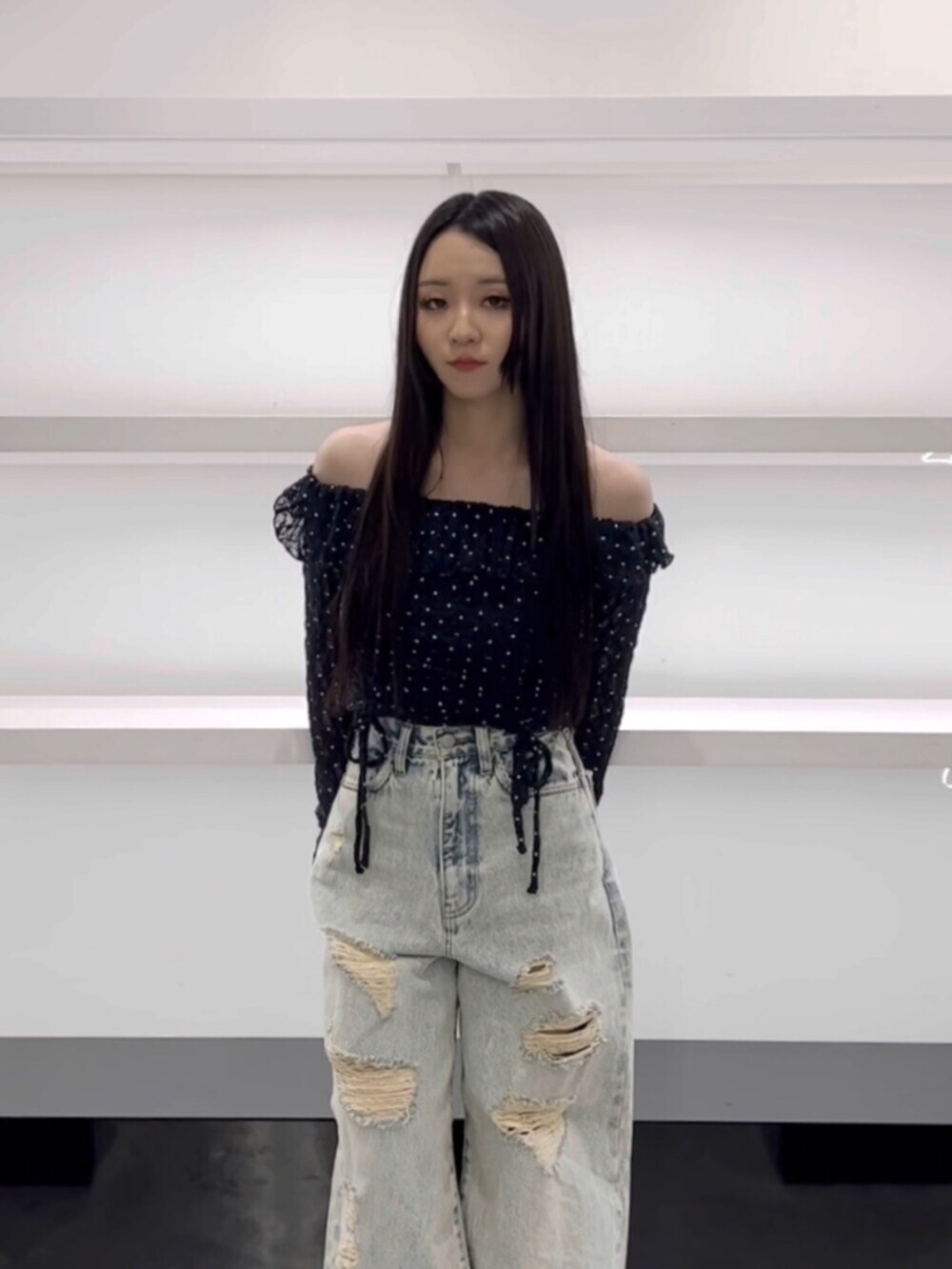 ブラック系のスニーカー、ブルー系のTシャツ/カットソー、ブルー系のデニムパンツを着用したレディースの春コーディネートの4枚目の写真