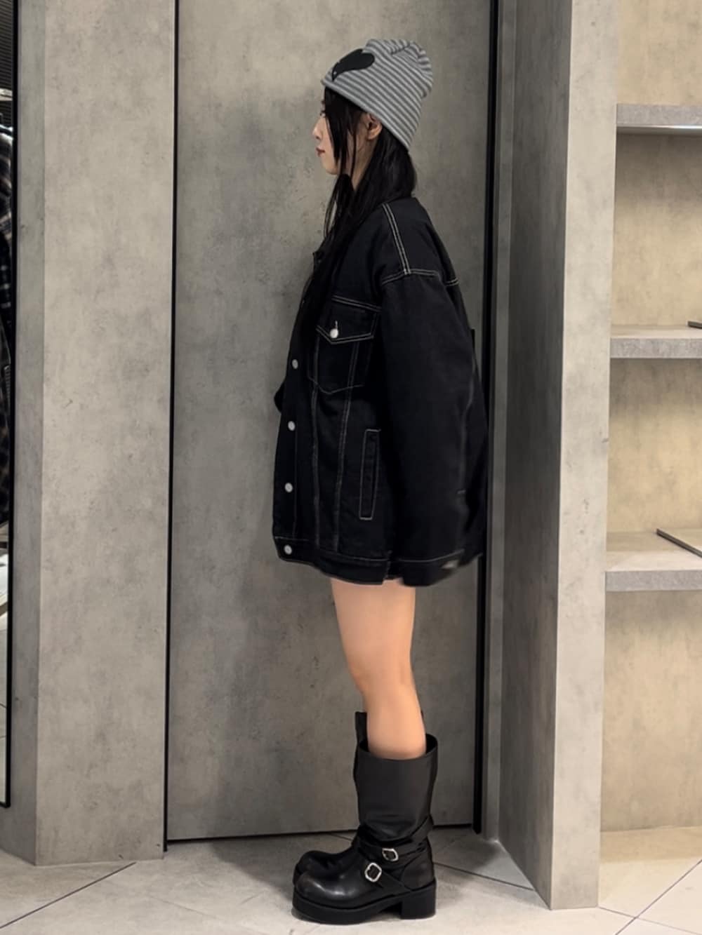 ブルー系のブルゾン、ブラック系のニット/セーター、ブルー系のスカートを着用したレディースの冬コーディネートの3枚目の写真