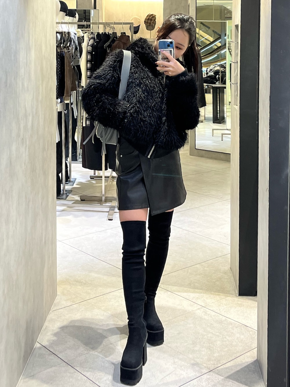 ブラック系のブーツ、グレー系のハンドバッグ、ブラック系のスカートを着用したレディースの秋コーディネートの2枚目の写真