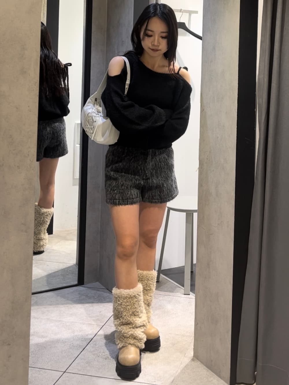 ホワイト系のブルゾン、ブラック系のニット/セーター、グレー系のその他パンツを着用したレディースの冬コーディネートの2枚目の写真