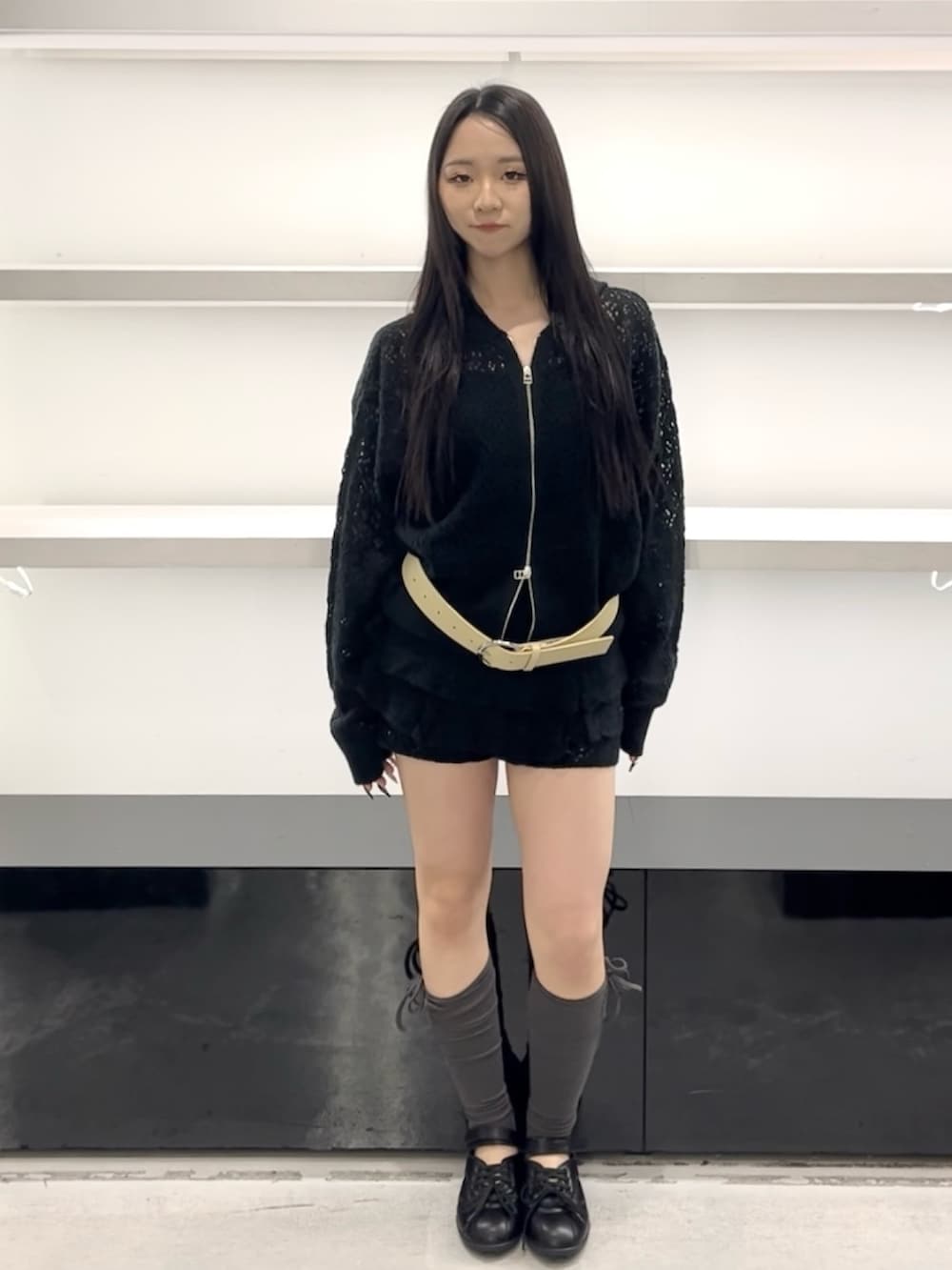 ブラック系のパーカー、ブラック系のスカート、ブラック系のスニーカーを着用したレディースの春コーディネートの2枚目の写真