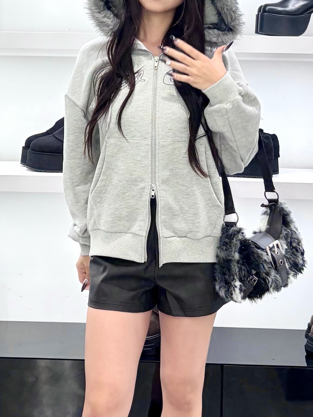 グレー系のパーカー、ブラック系のショルダーバッグ、ブラック系のその他パンツを着用したレディースの秋コーディネートの10枚目の写真