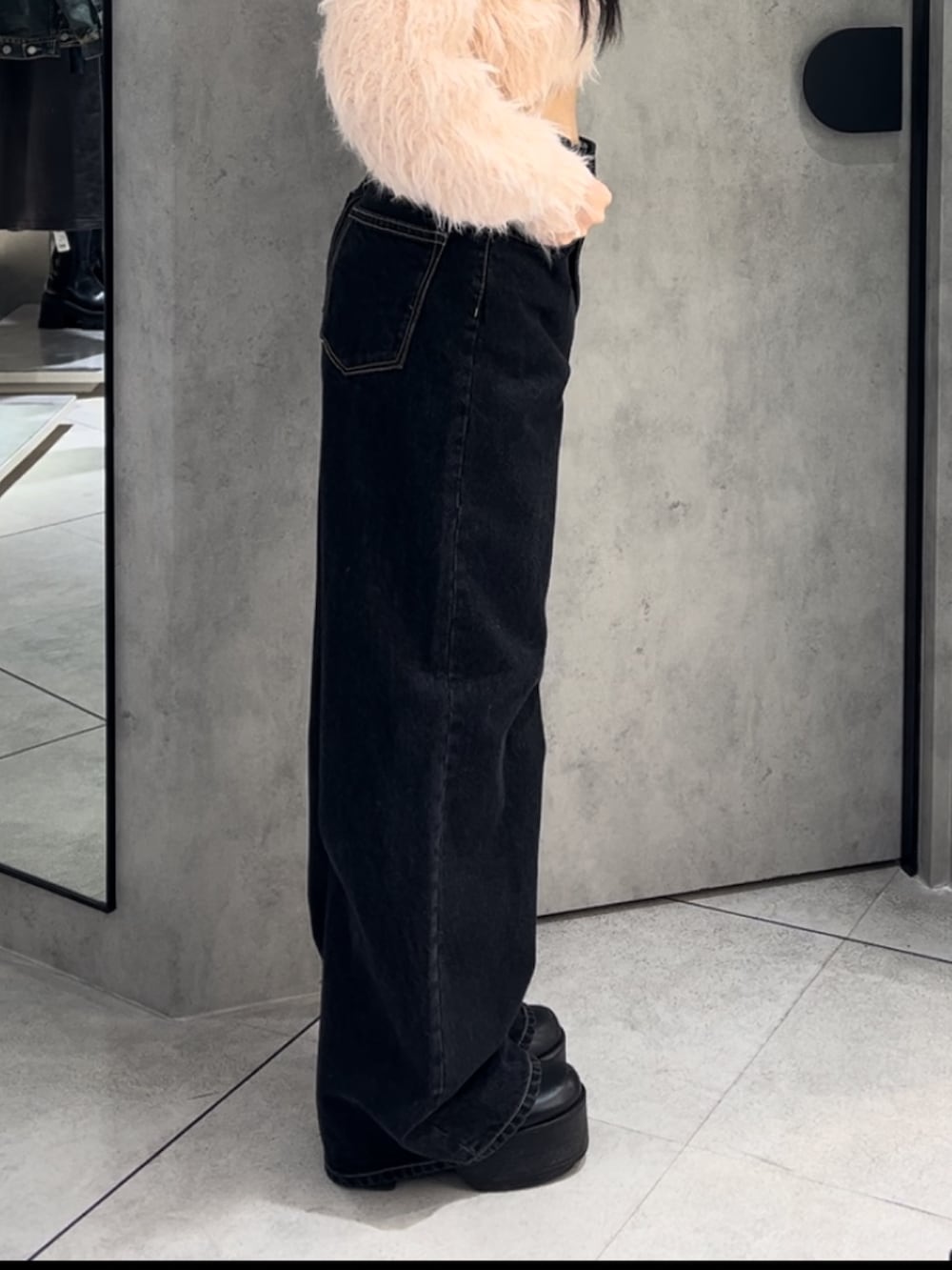 ブルー系のブルゾン、ブルー系のデニムパンツ、ブラック系のハンドバッグを着用したレディースの冬コーディネートの6枚目の写真