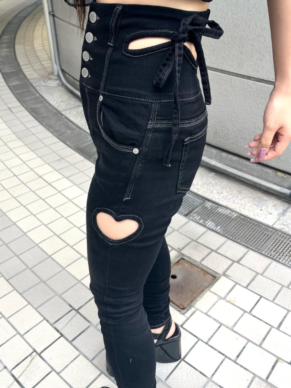 ブラック系のサンダル、ブラック系のデニムパンツを着用したレディースの夏コーディネートの9枚目の写真