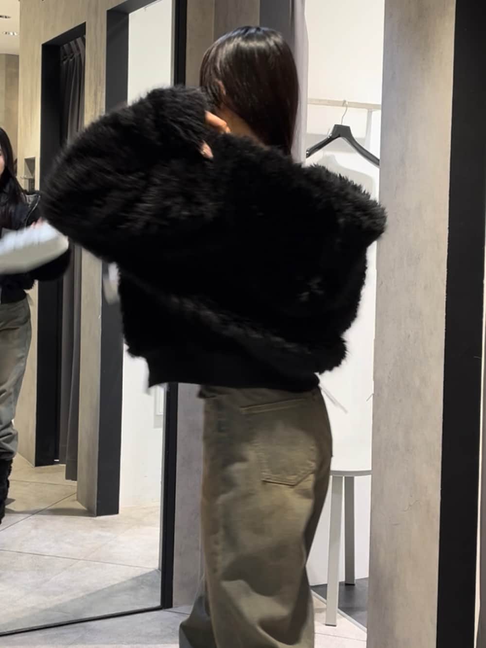 ブラック系のブルゾン、ホワイト系のニット/セーター、ブルー系のデニムパンツを着用したレディースの冬コーディネートの7枚目の写真