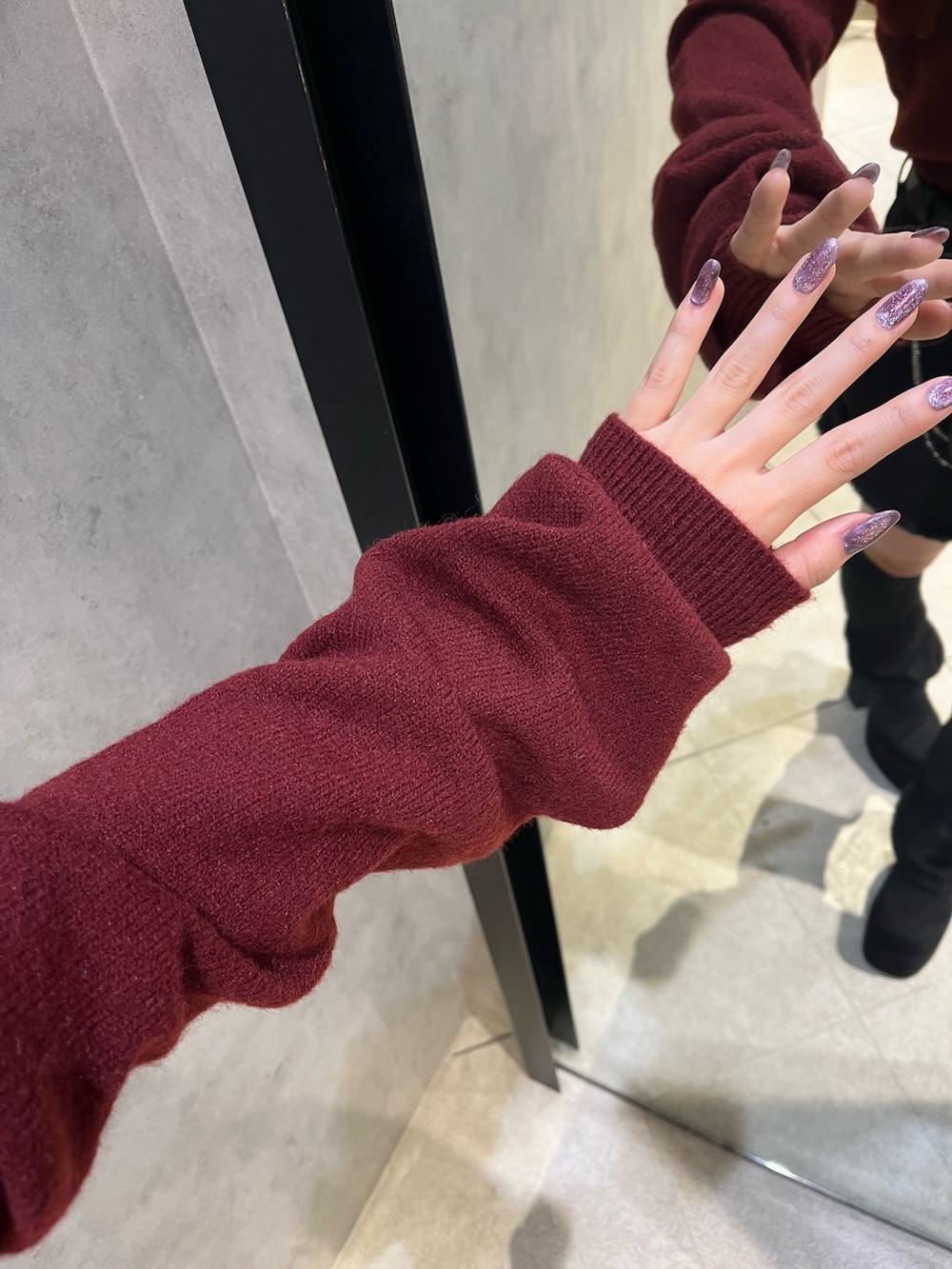 ブラック系のスカート、ブラック系のハンドバッグ、ブラック系のブーツを着用したレディースの秋コーディネートの9枚目の写真